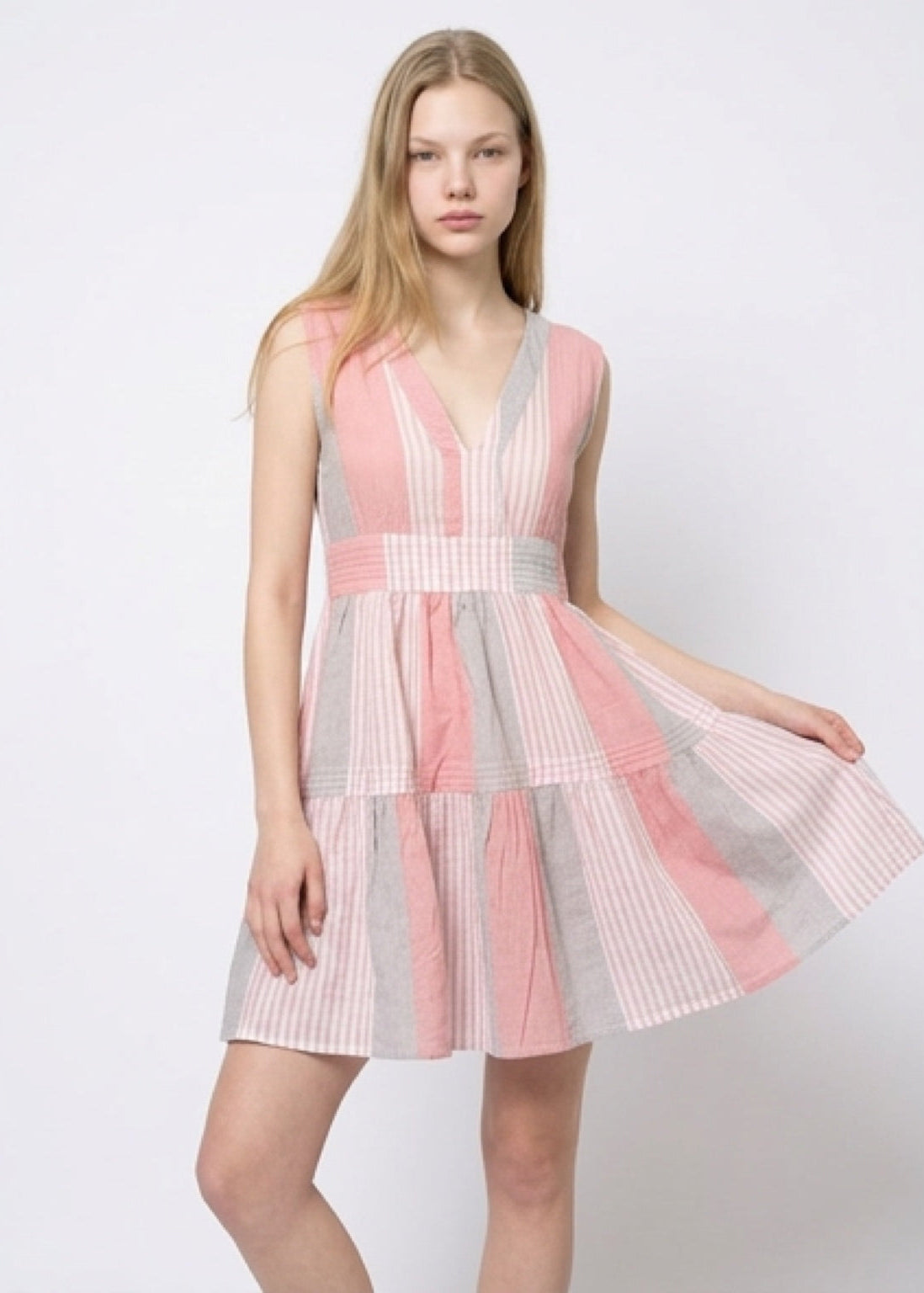 Model wearing a pink and gray dress on a white background