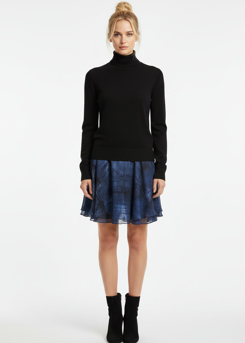 Woman wearing a black turtleneck sweater and blue skirt on a white background