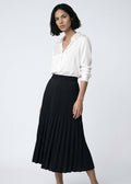 Woman wearing a white blouse and black pleated skirt on a white background