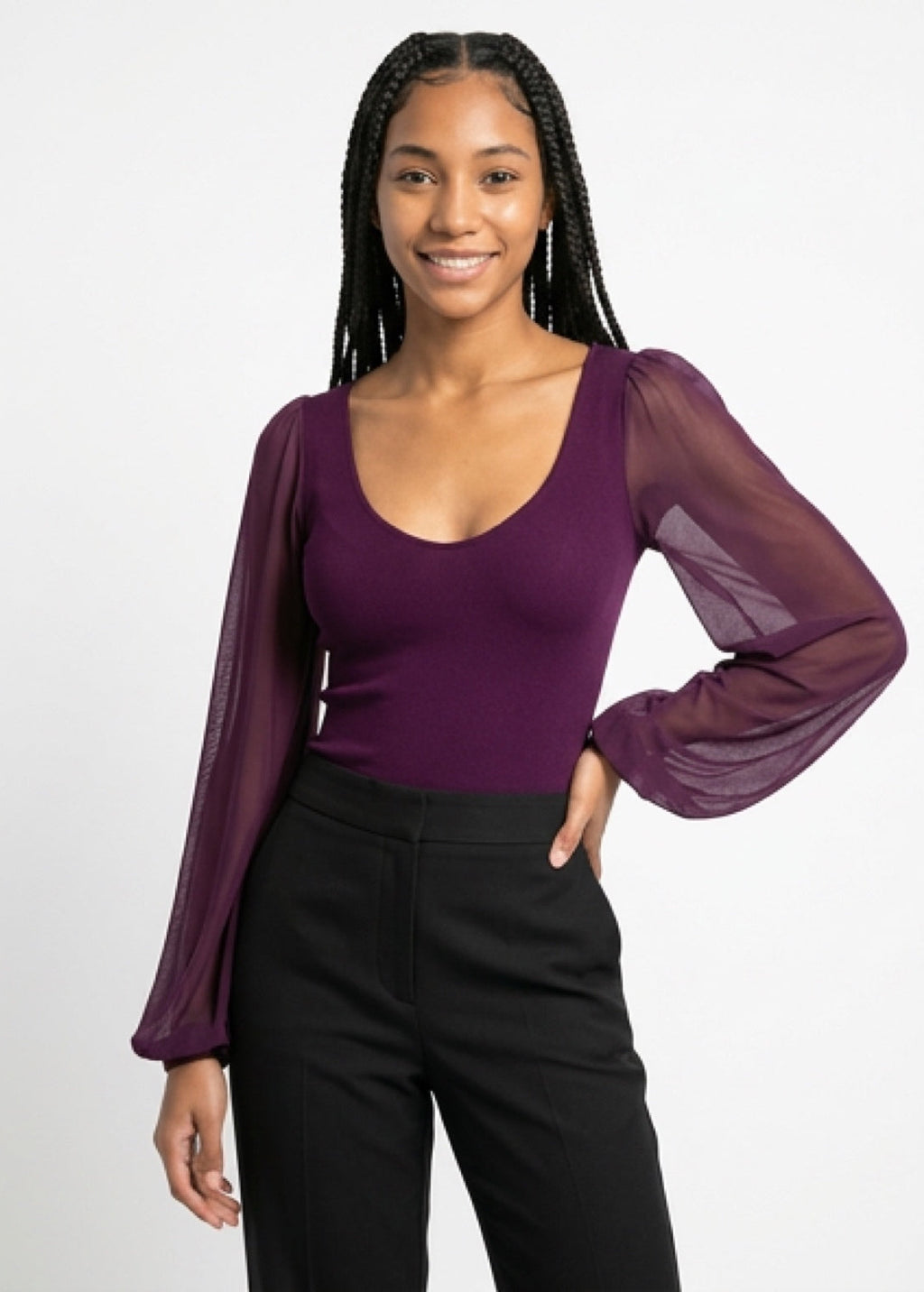 Woman wearing a purple top with sheer sleeves against a white background