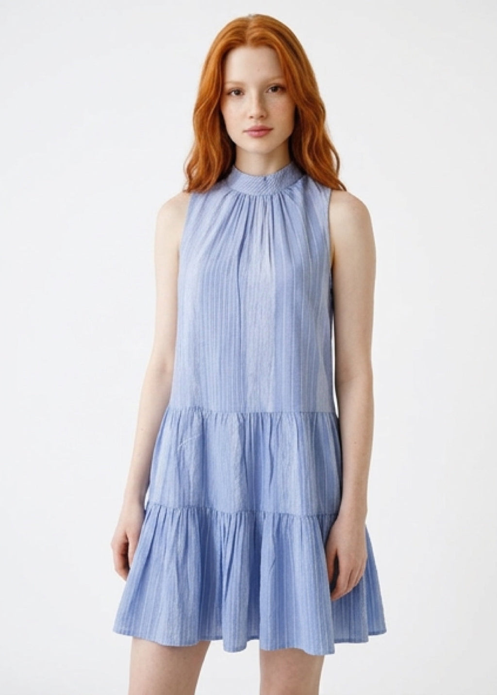 Woman wearing a light blue dress with a white background