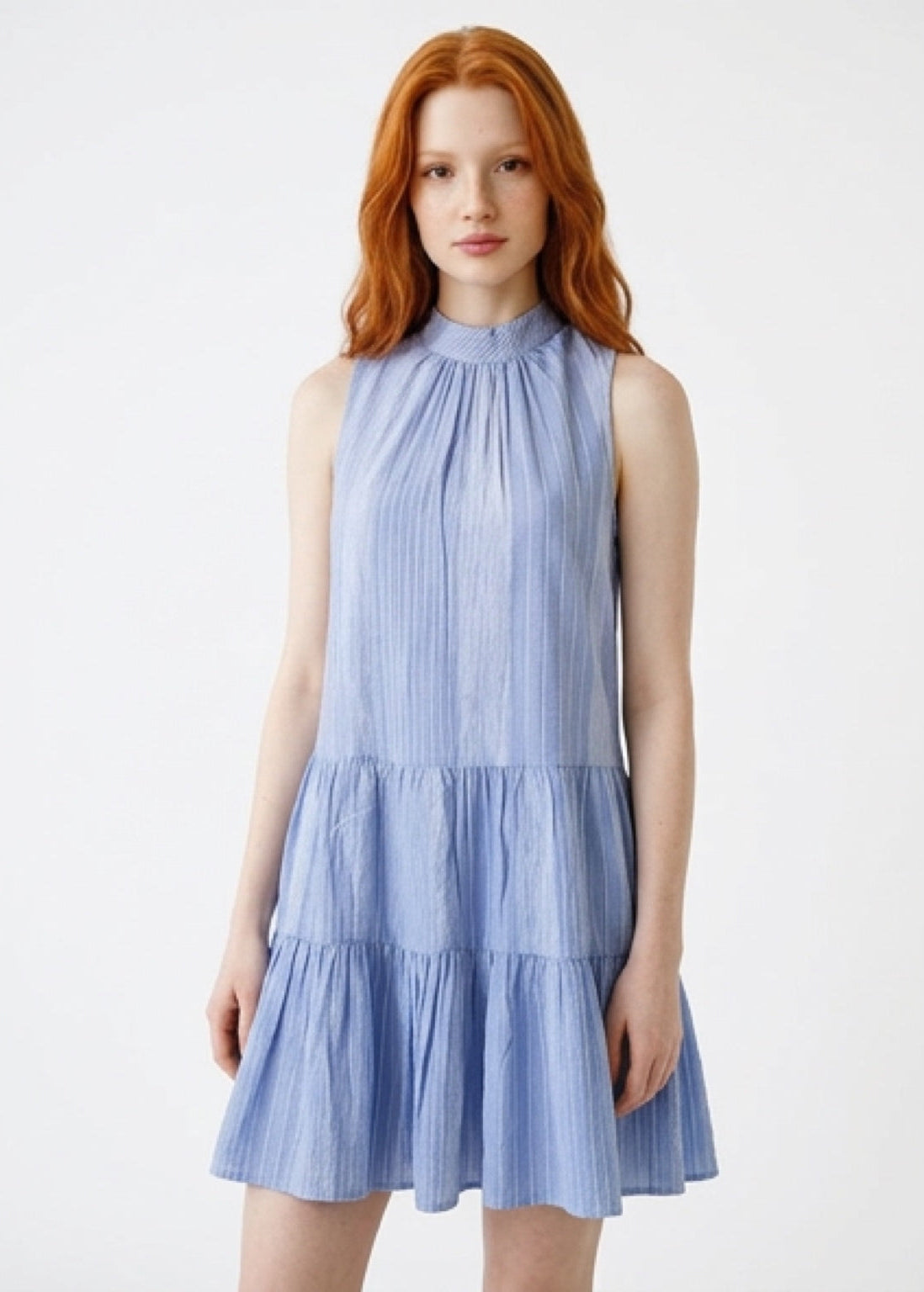 Woman wearing a light blue dress with a white background