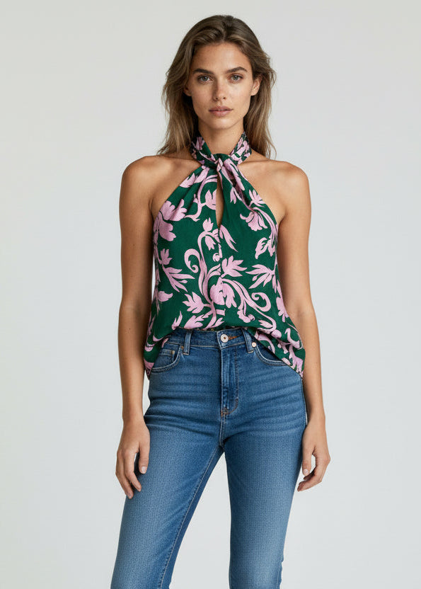Woman wearing a floral top and blue jeans on a white background