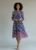 Woman wearing a floral dress against a plain background