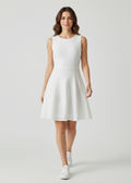 Woman wearing a white sleeveless dress on a plain background