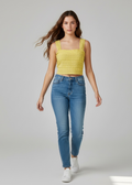 Woman wearing a yellow top and blue jeans on a white background