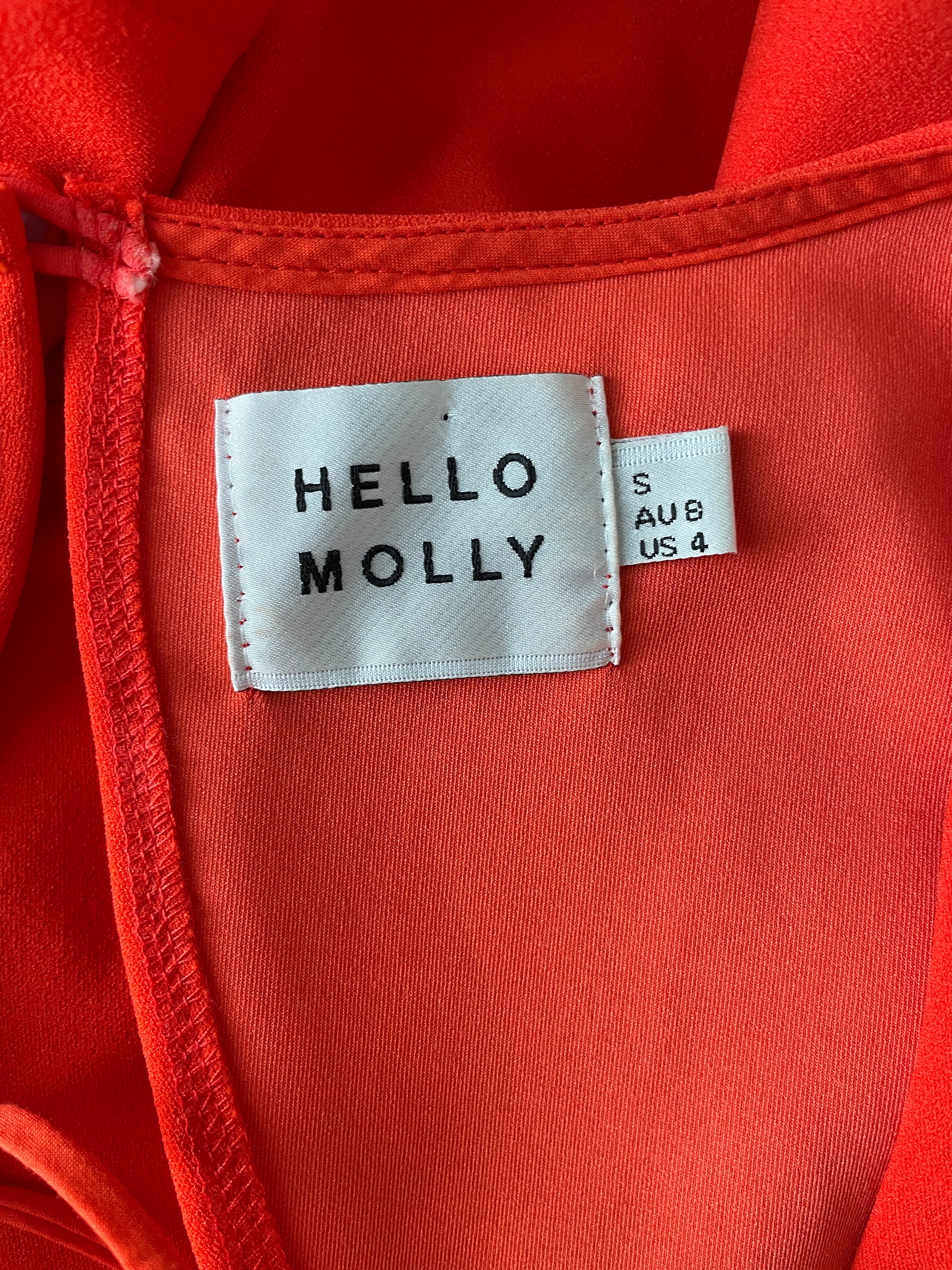 Close-up of a coral garment with 'Hello Molly' label