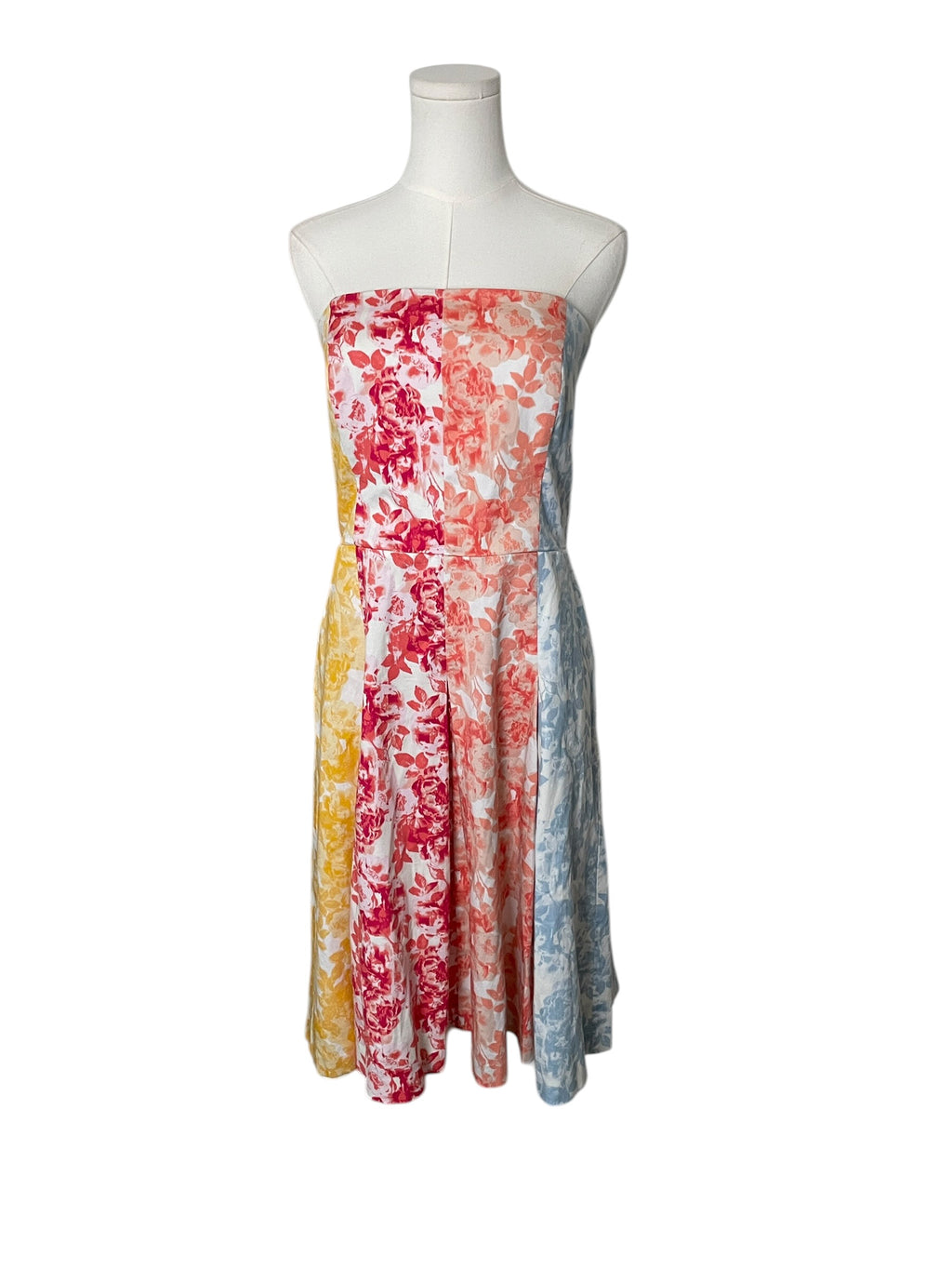 Colorful strapless dress on a mannequin against a white background