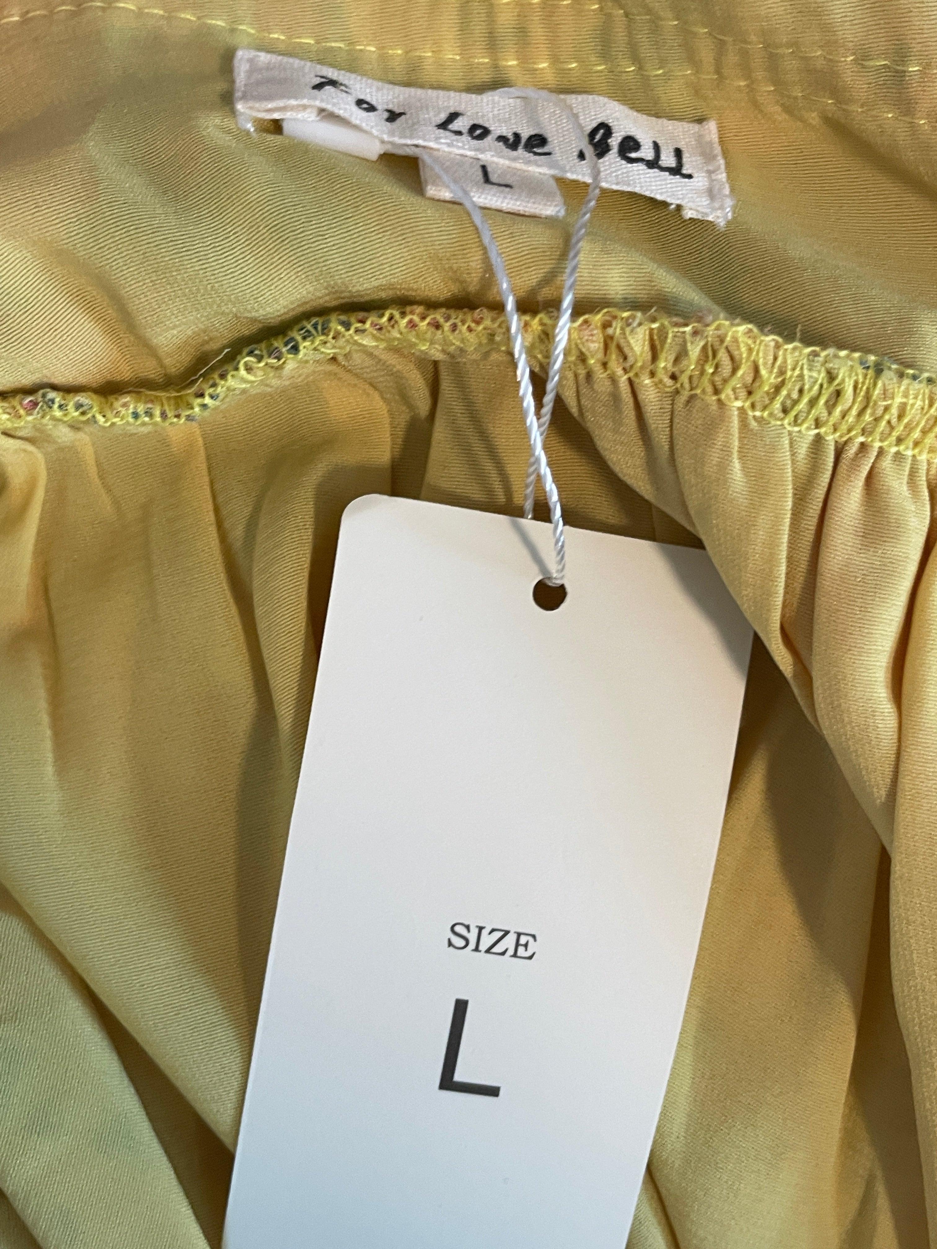Close-up of a yellow garment with a size label and tag.