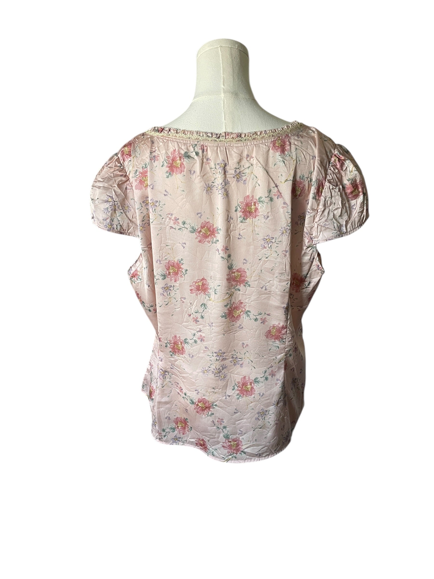 Floral blouse on a mannequin against a white background