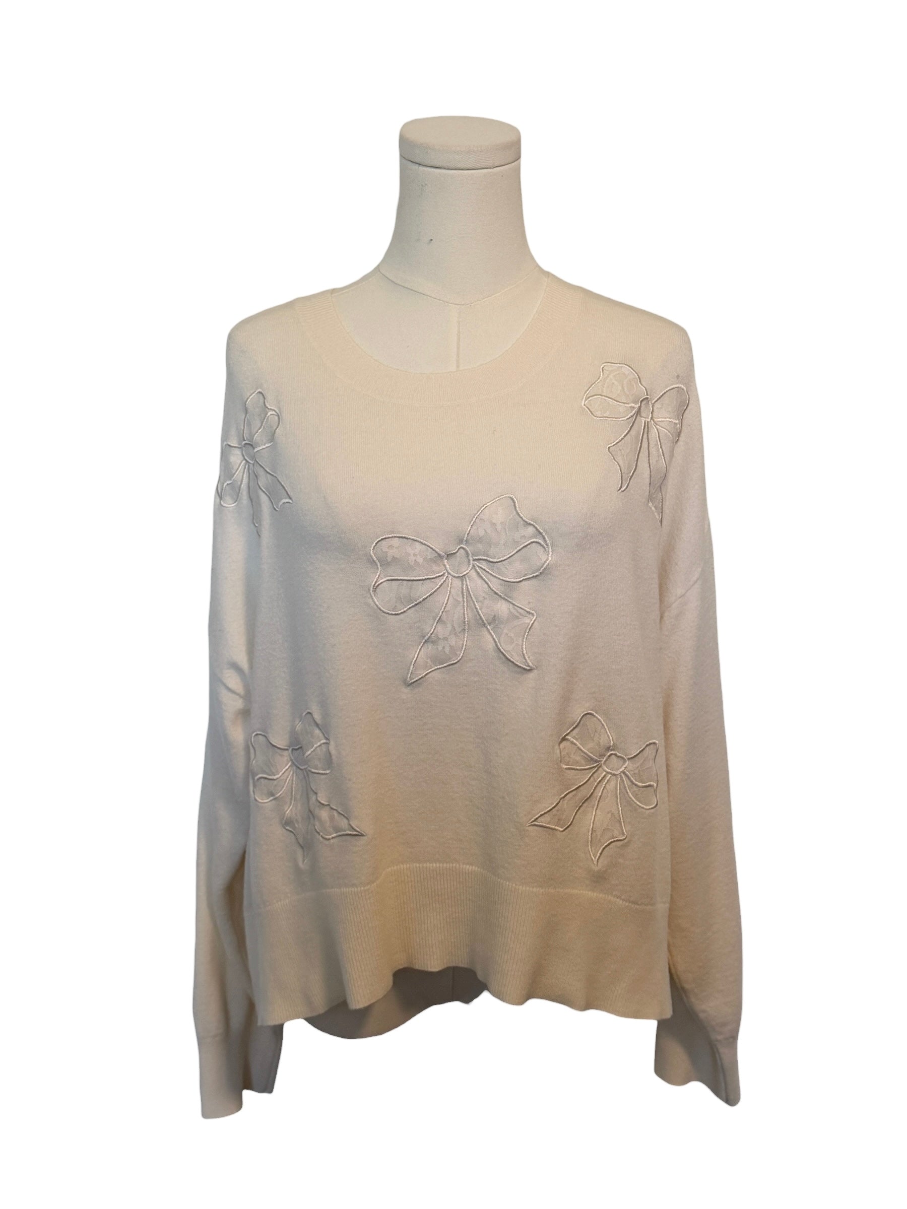 Beige sweater with bow details on a mannequin against a white background