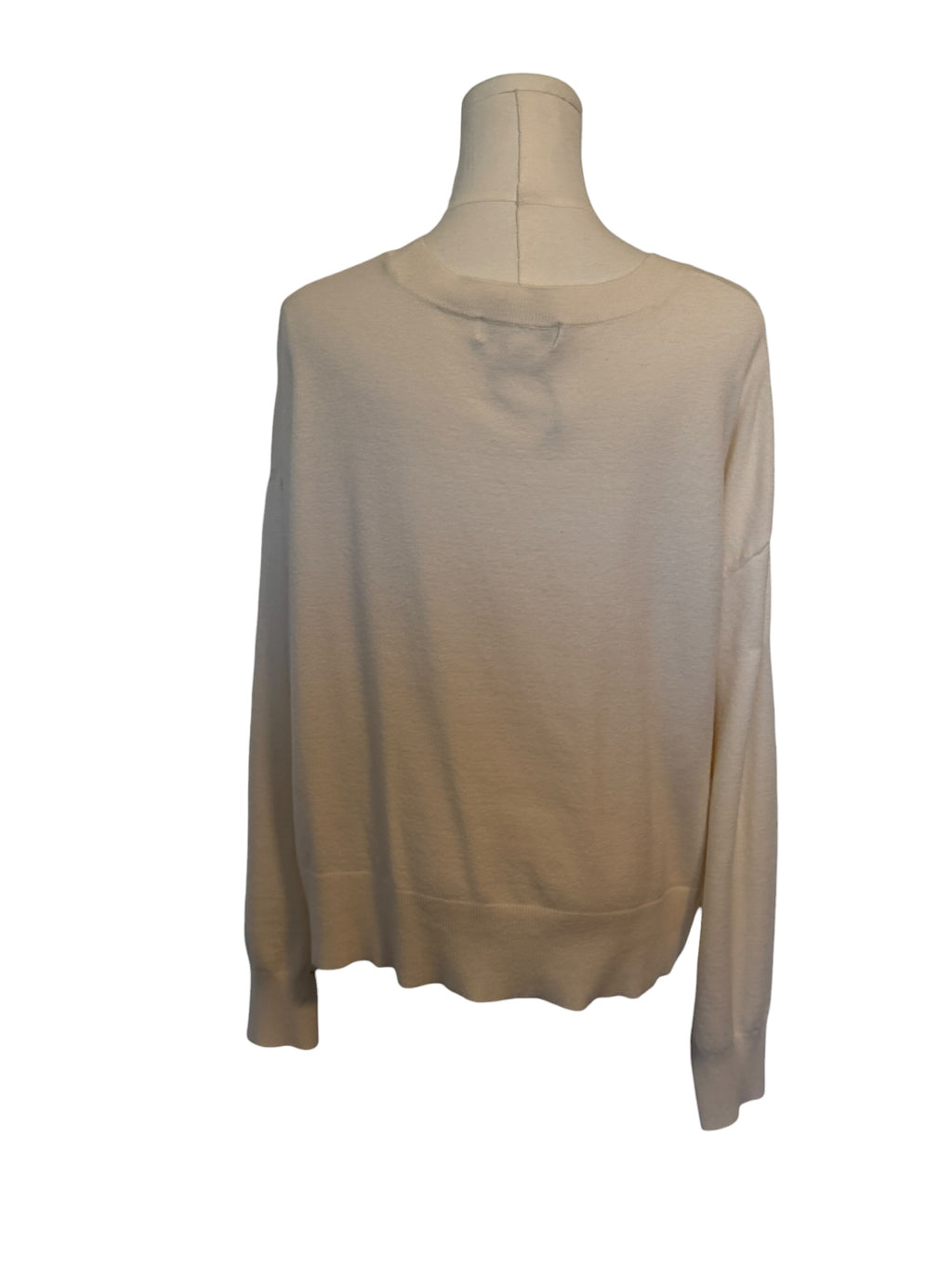 Beige long-sleeve top on a mannequin against a white background
