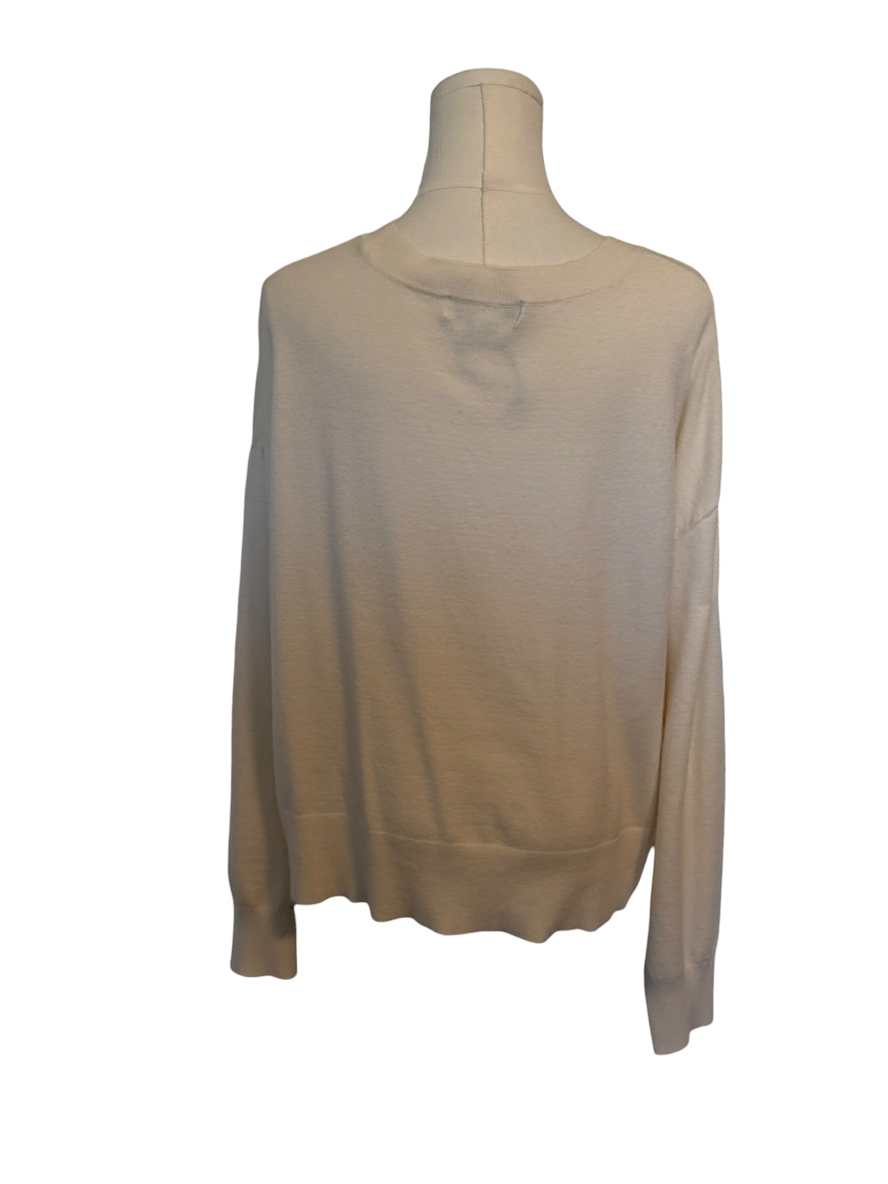 Beige long-sleeve top on a mannequin against a white background
