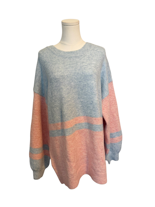 Color-blocked sweater on a mannequin against a white background
