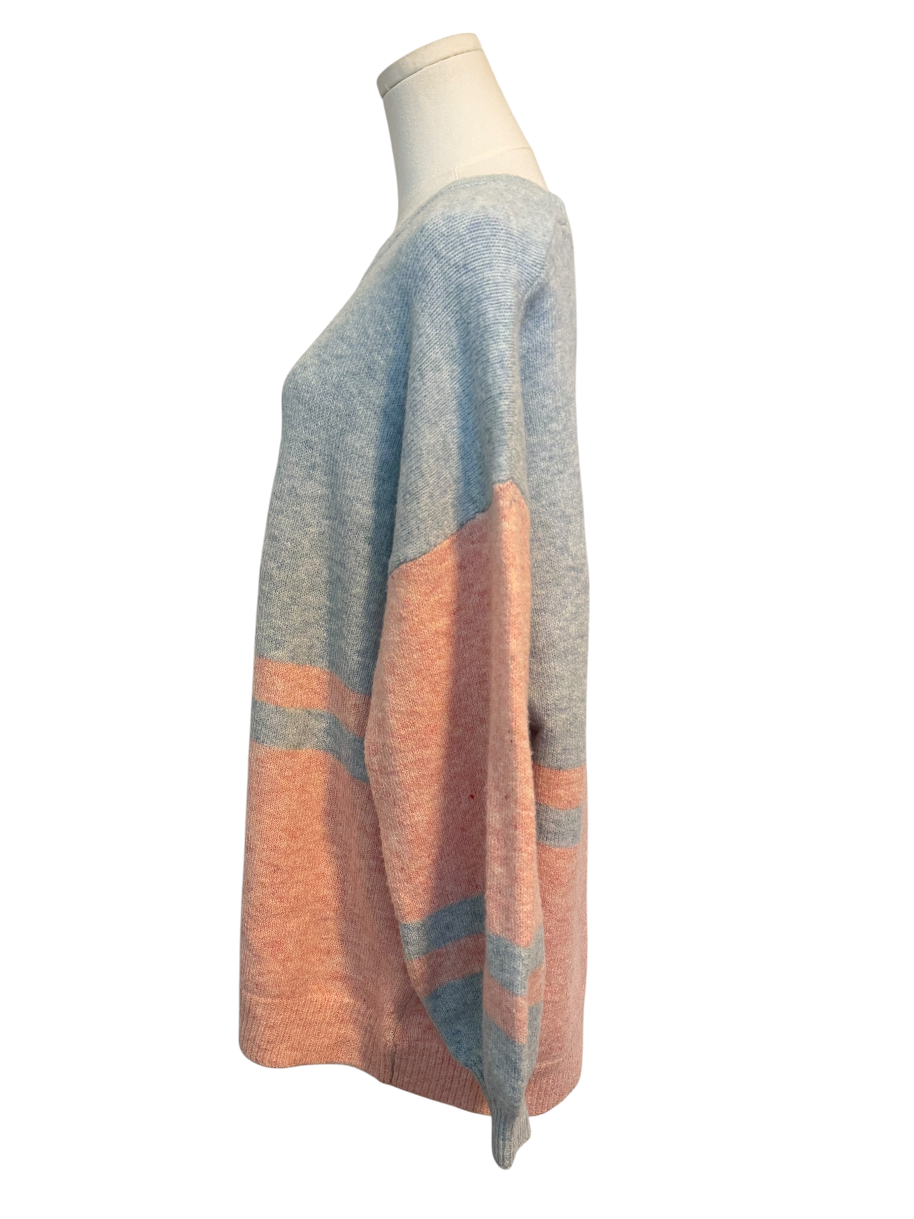 Mannequin wearing a multicolored sweater with blue and orange pattern on a white background