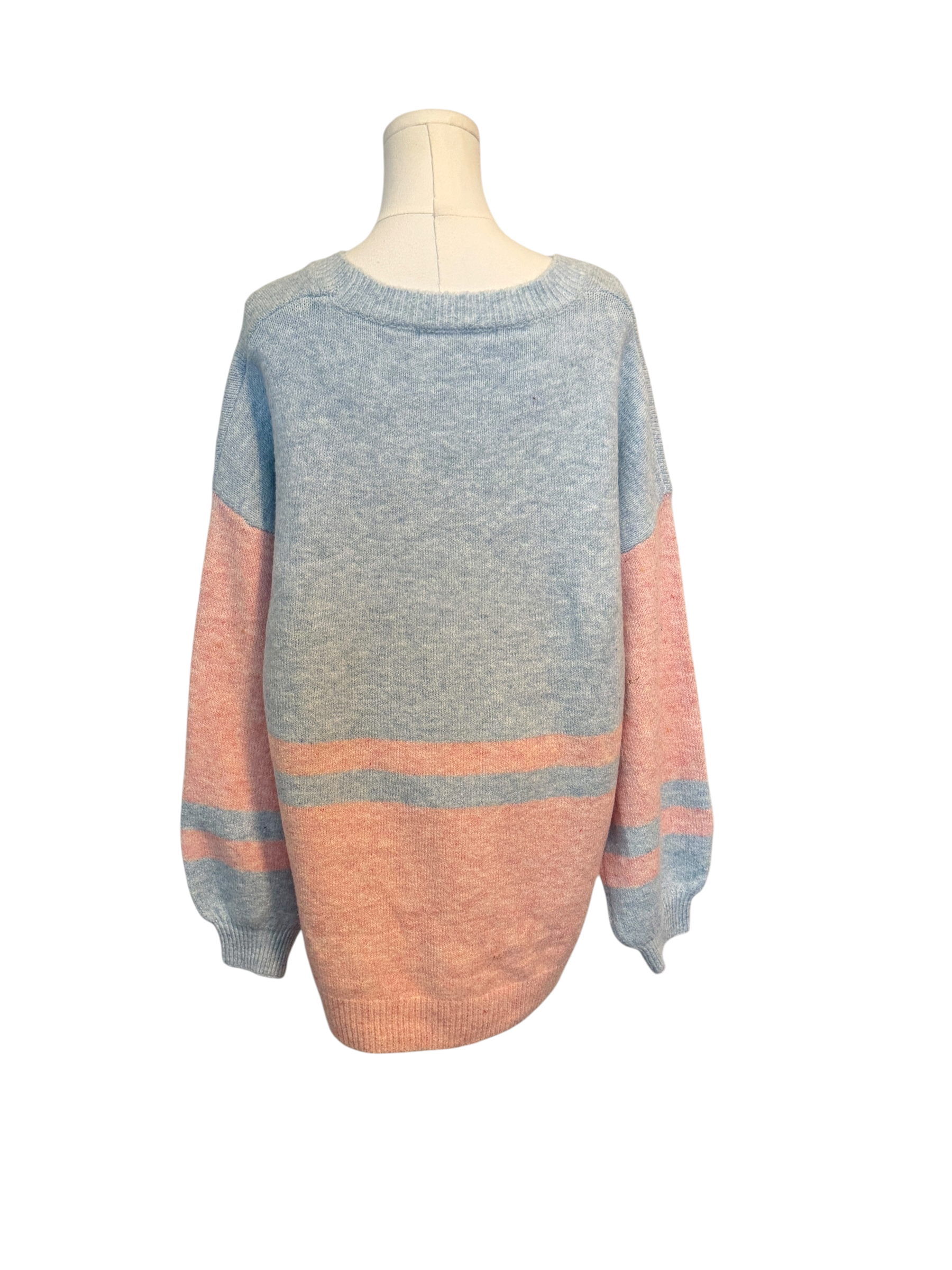 Two-tone pink and gray sweater on a mannequin against a white background