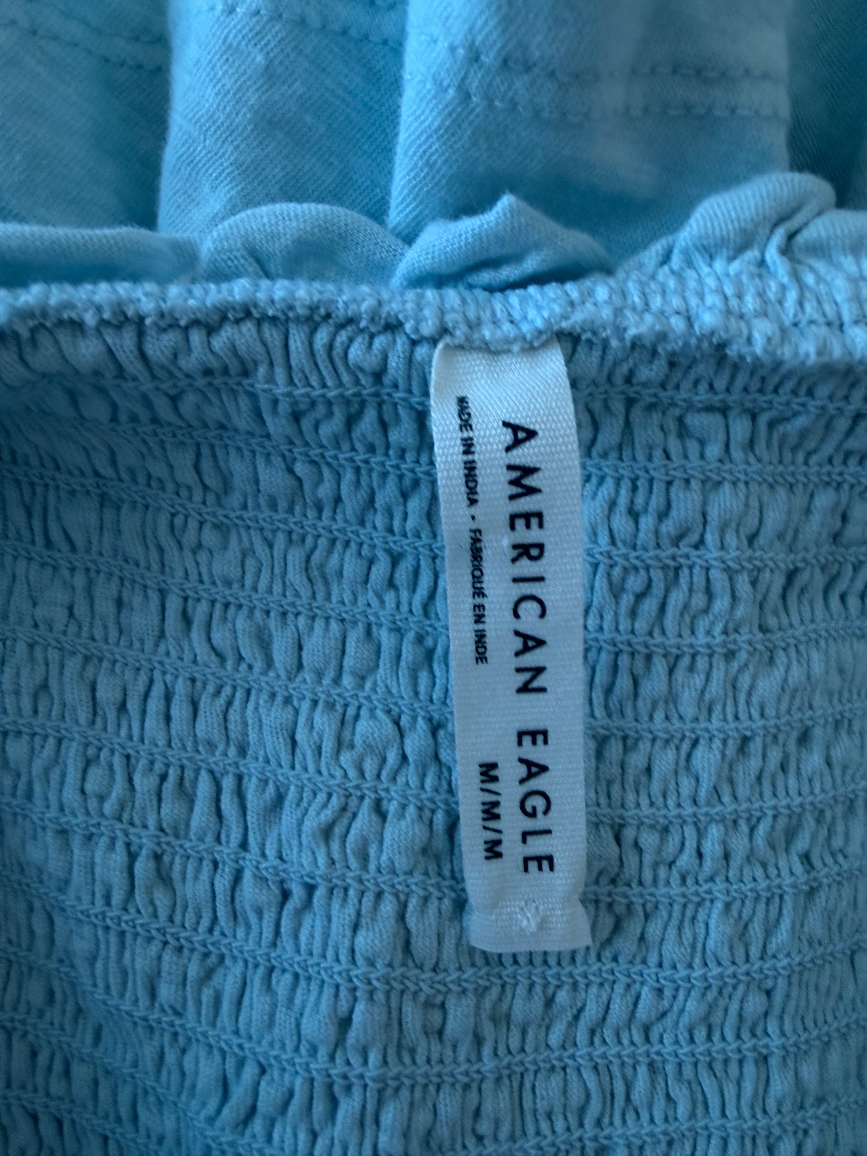 Close-up of an American Eagle label on textured blue fabric.