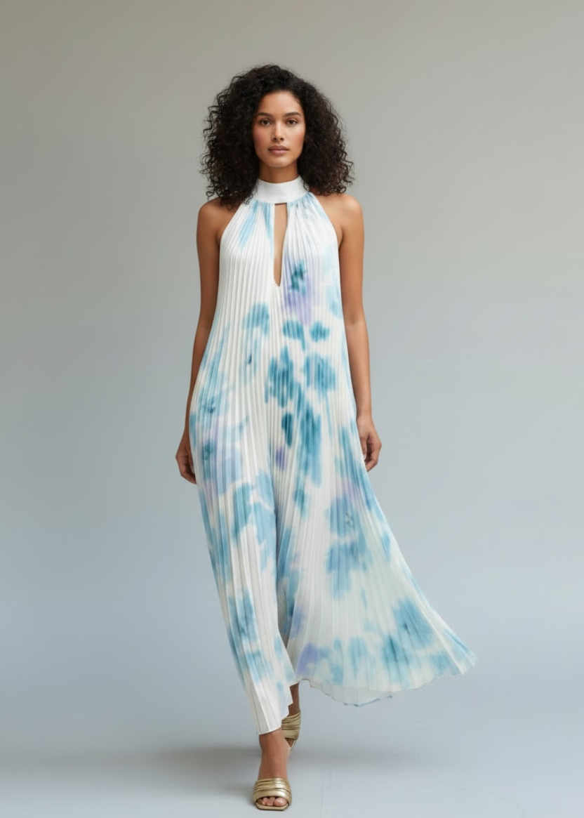 Woman wearing a blue and white tie-dye dress on a plain background