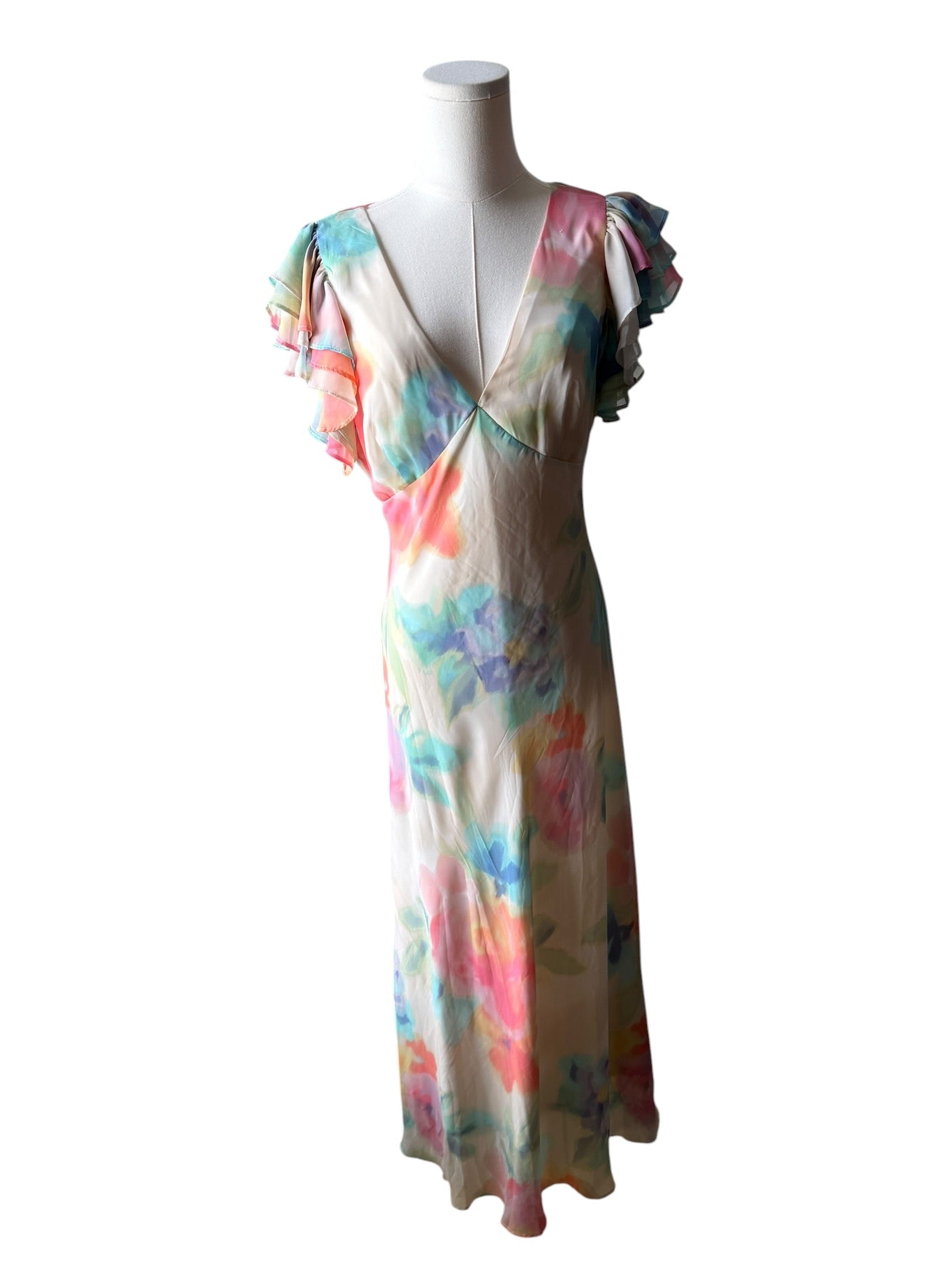 Colorful floral dress on a mannequin against a white background