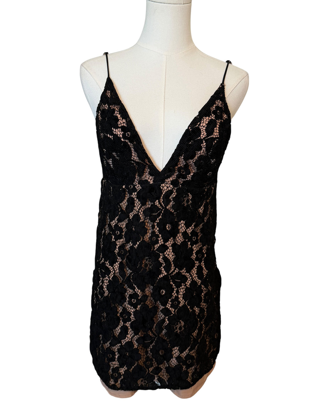 Black lace dress on a mannequin against a white background