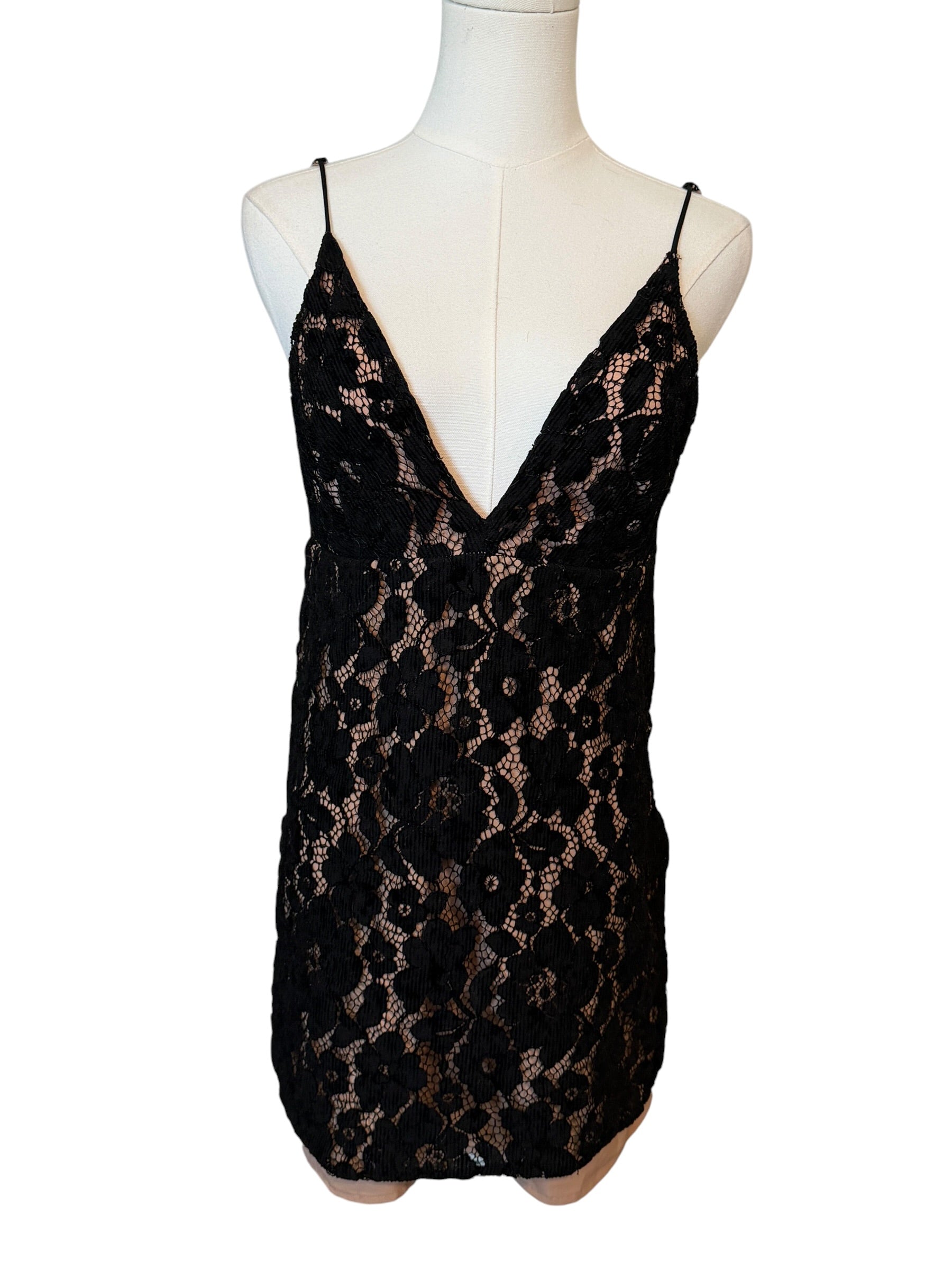 Black lace dress on a mannequin against a white background