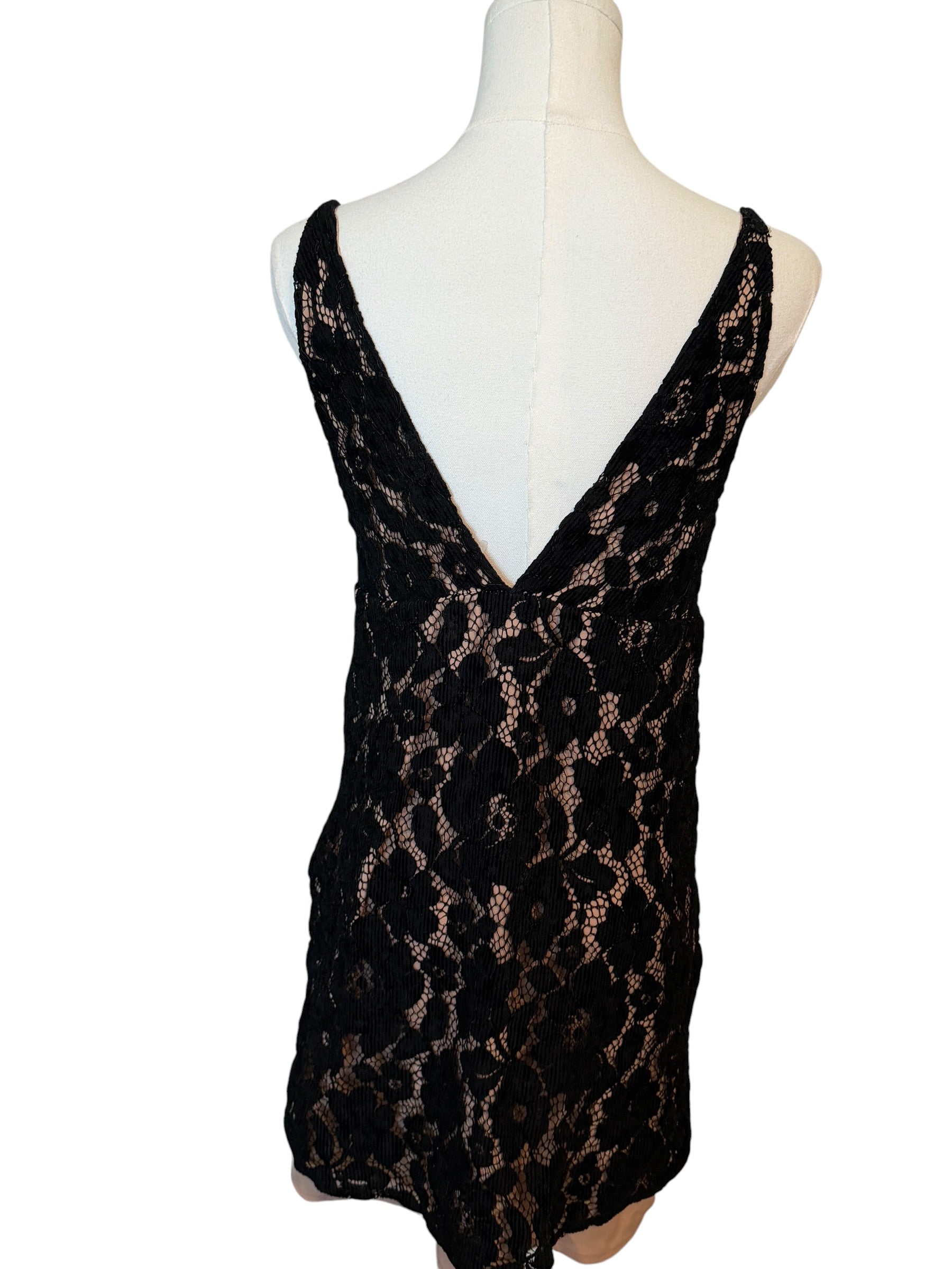 Black lace dress on a mannequin against a white background