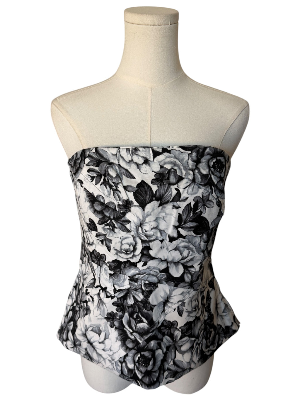 Black and white floral strapless top on a mannequin against a white background