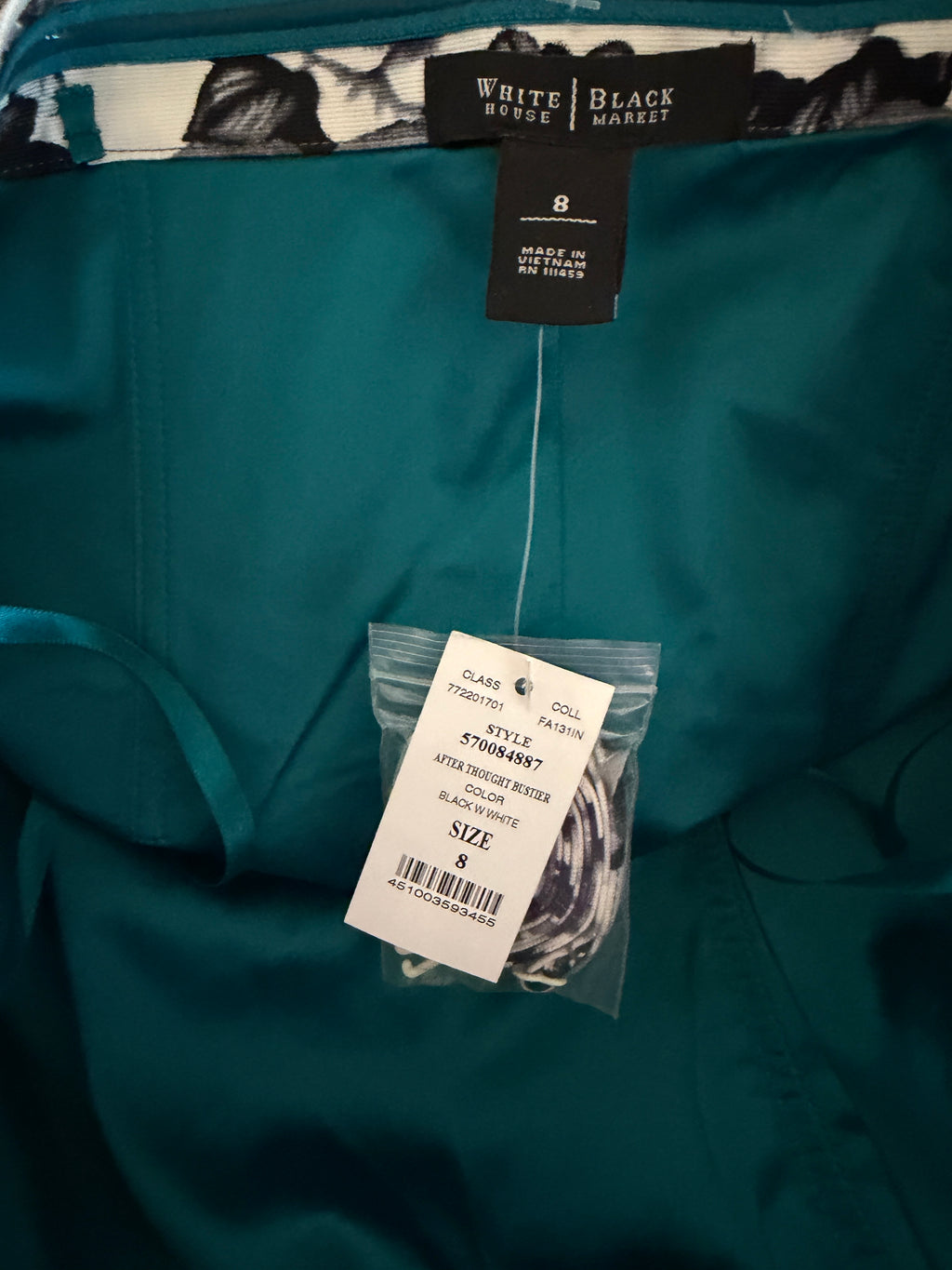 Teal shirt with tags from White Black Market and a label on a dark background