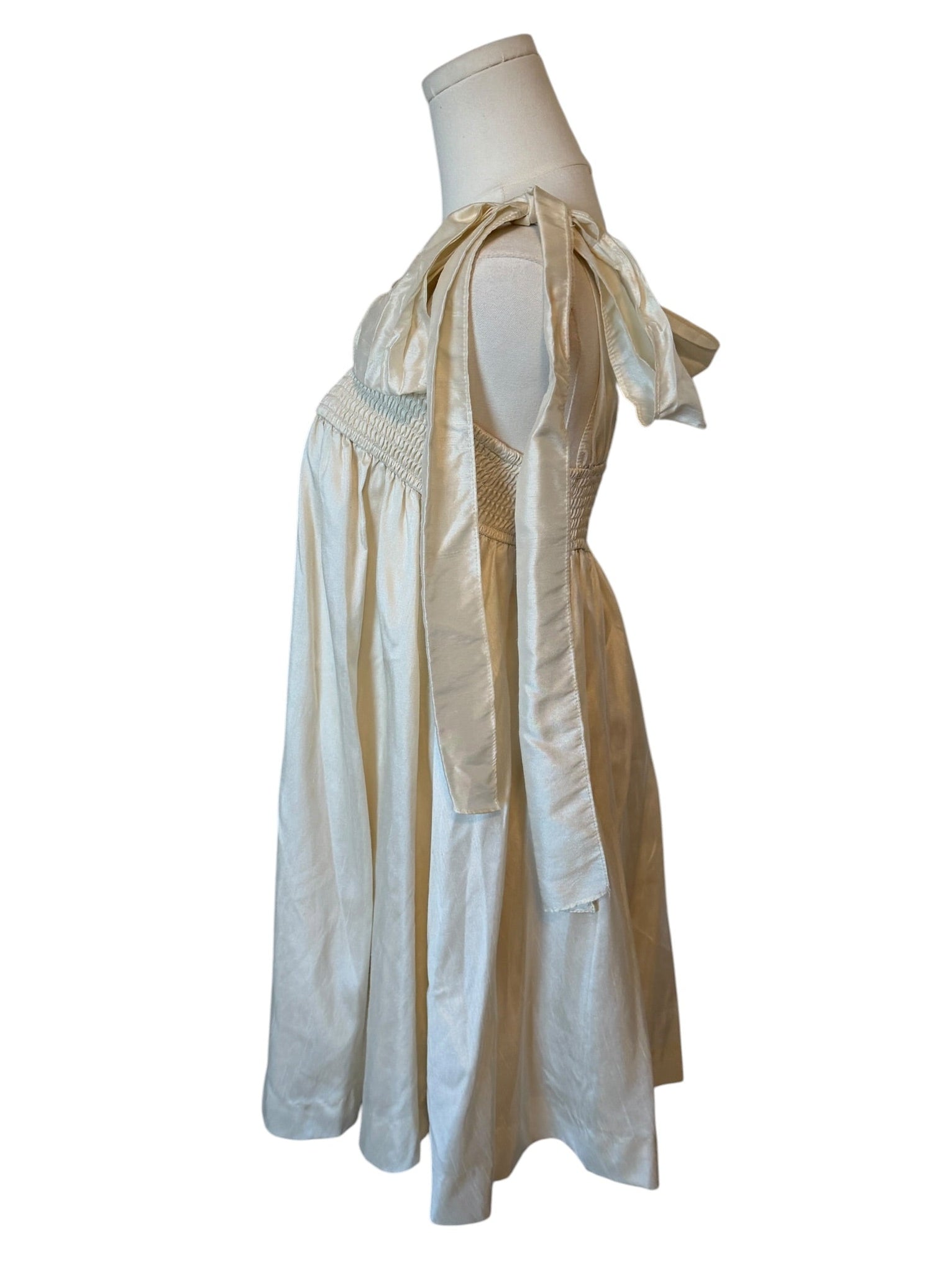 White dress with sheer sleeves on a mannequin against a white background