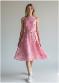 Woman wearing a pink floral dress against a plain background