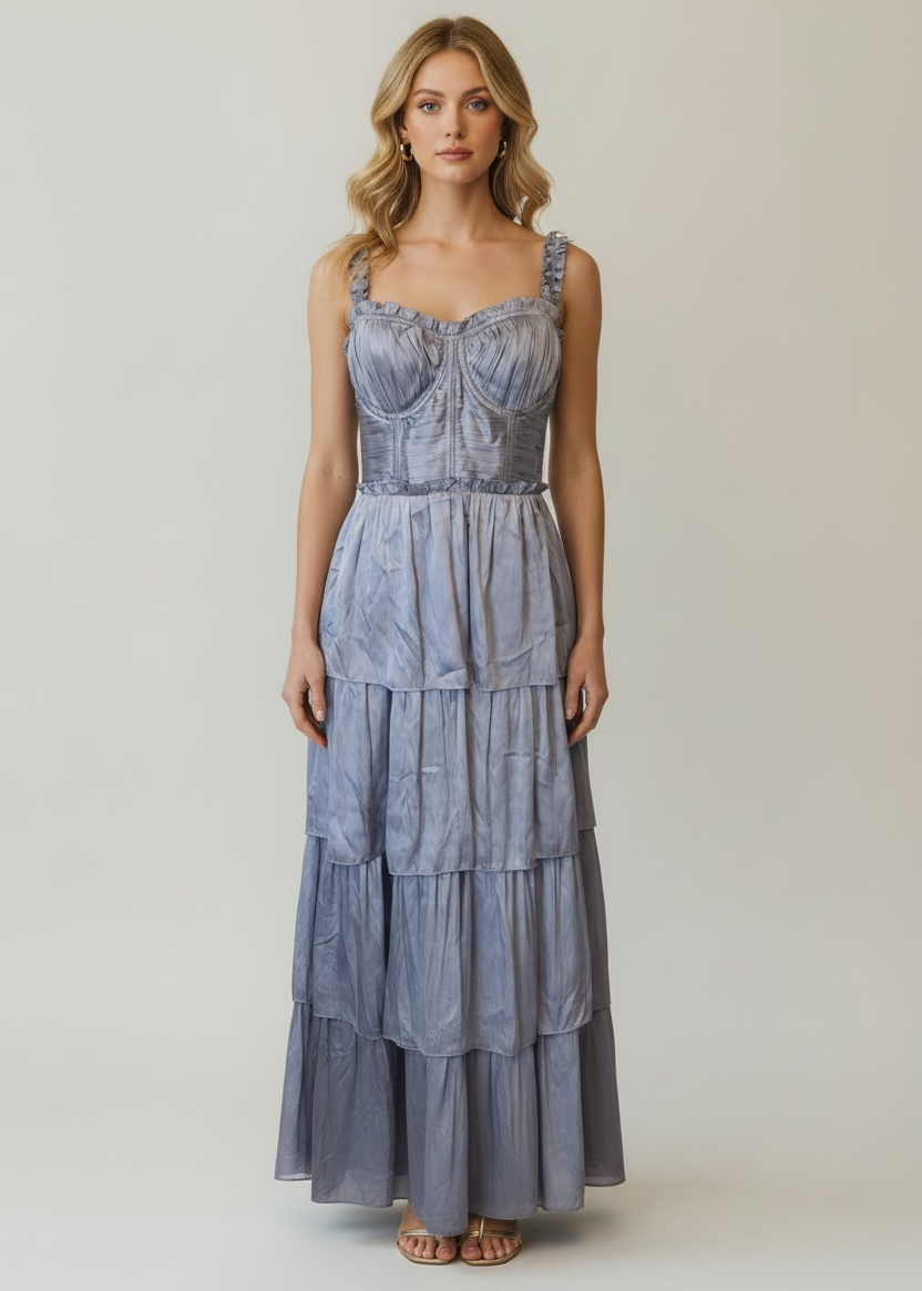 Woman wearing a blue tiered dress against a plain background