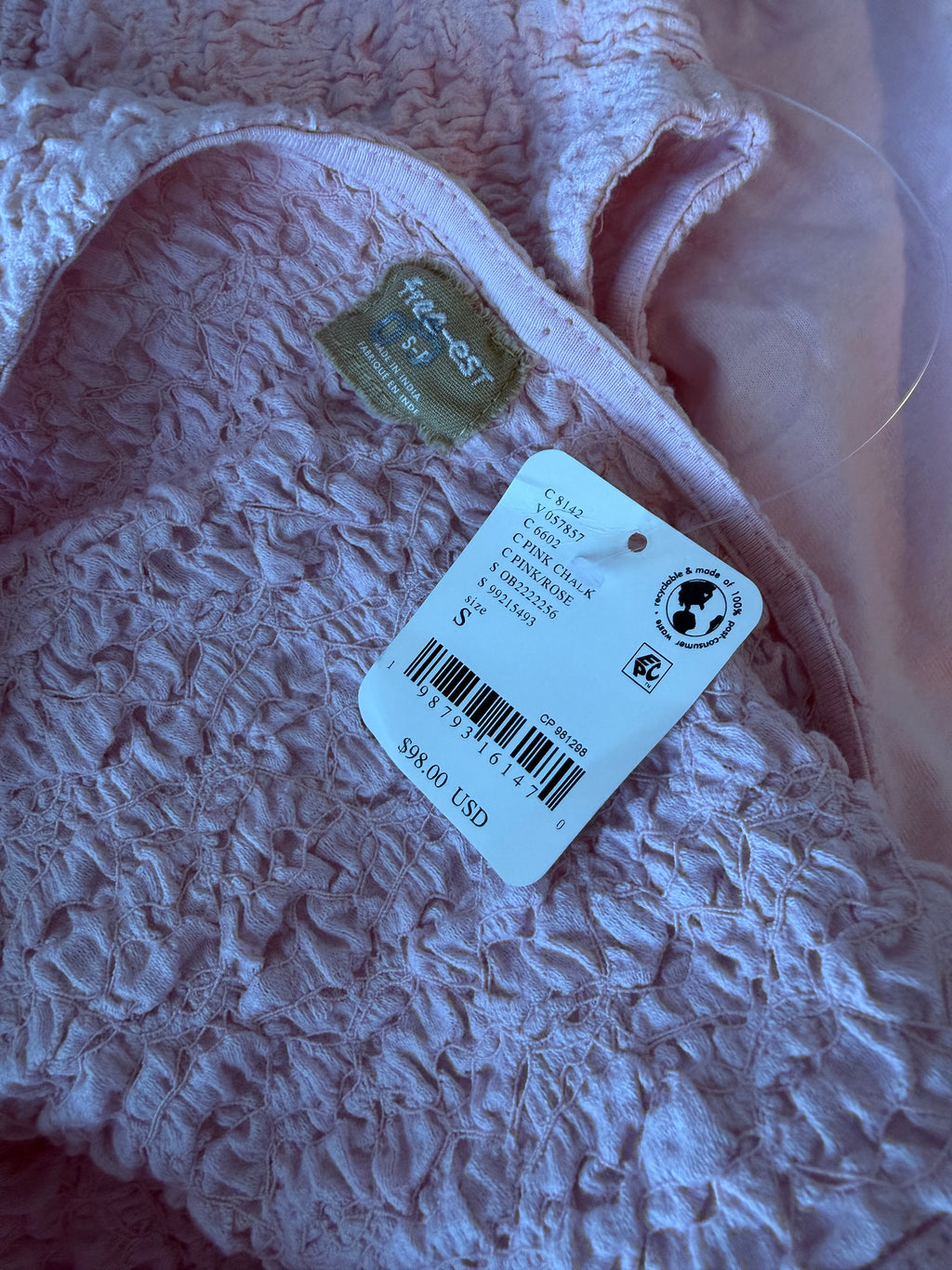Close-up of a textured fabric with a tag and label on it.