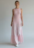 Woman wearing a pink dress against a plain background