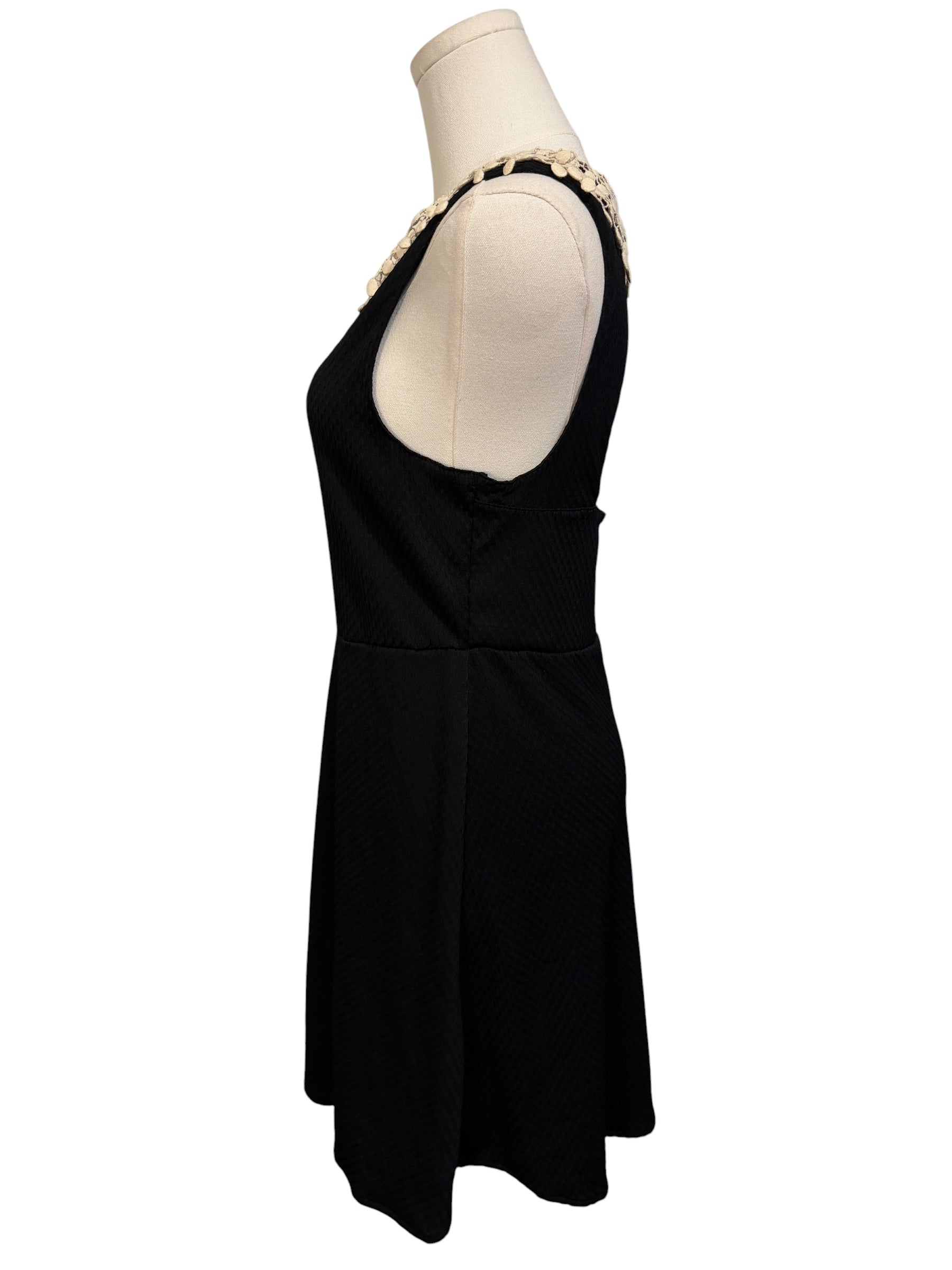 Black sleeveless dress on a mannequin against a white background