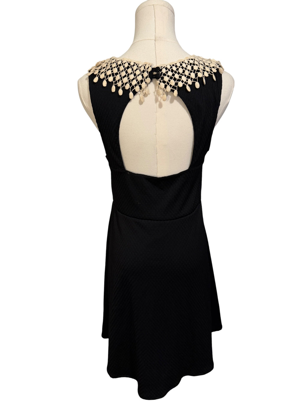 Black dress with beaded shoulder detail on a mannequin against a white background