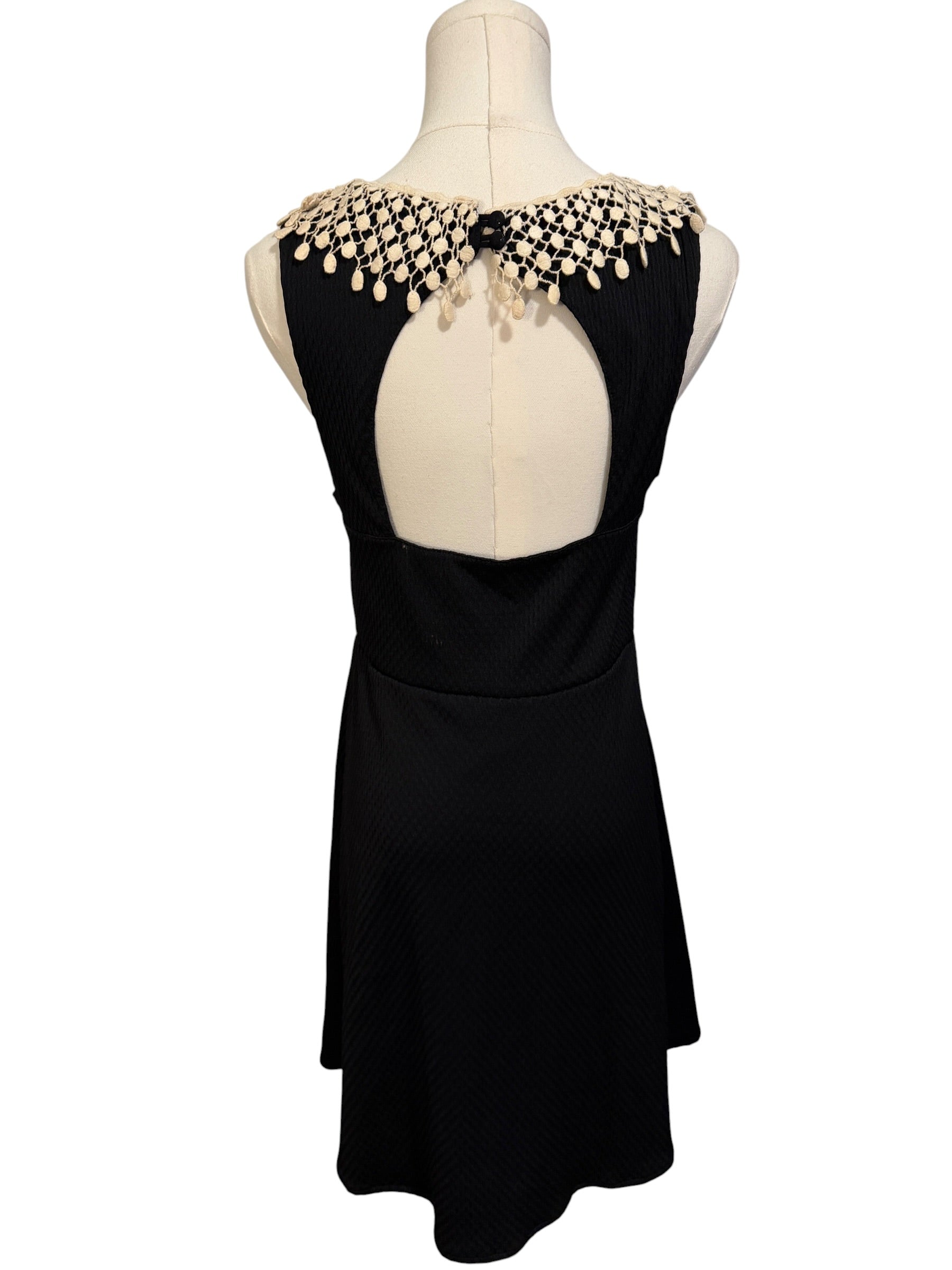 Black dress with beaded shoulder detail on a mannequin against a white background