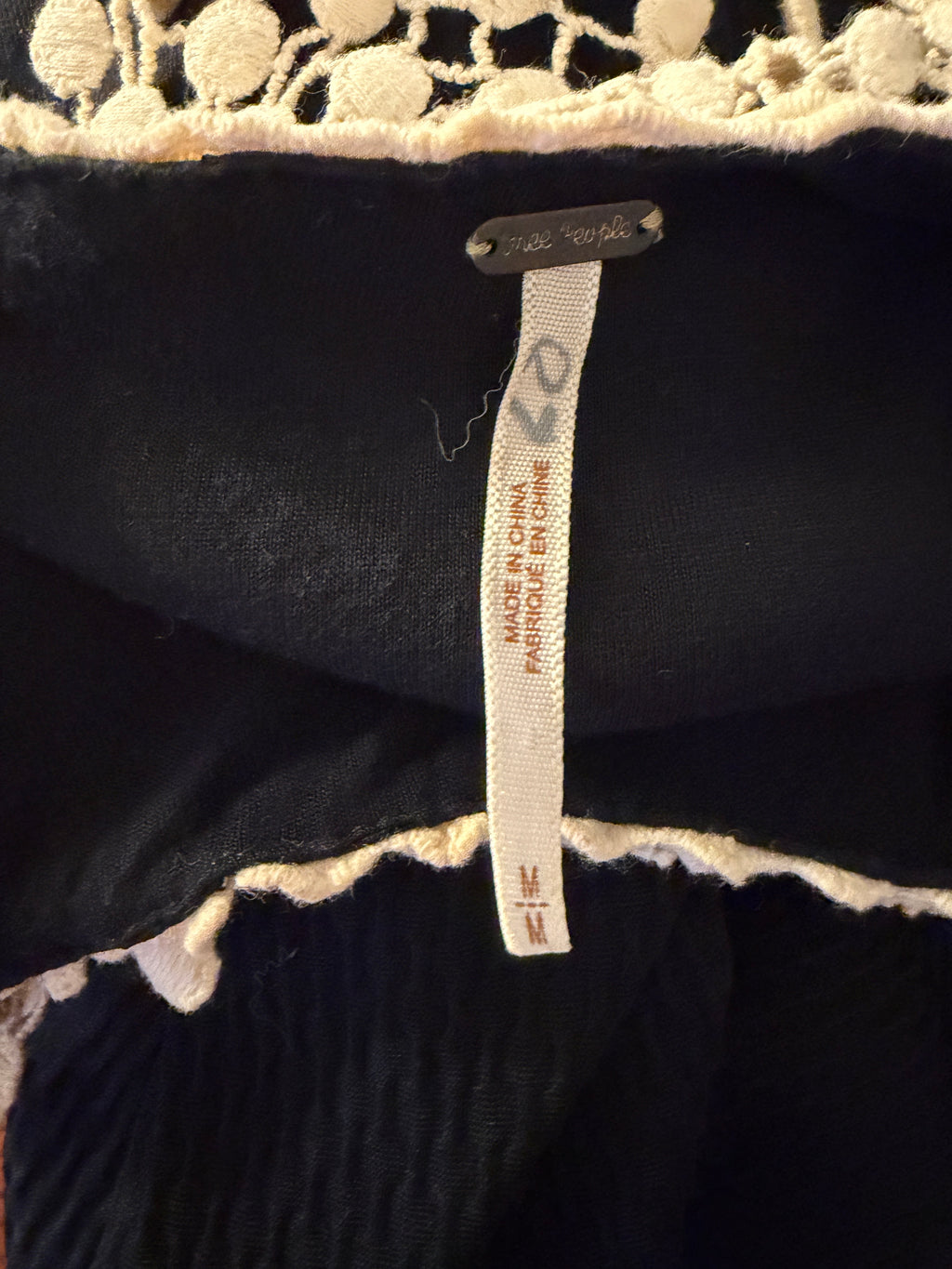 Close-up of a label on a black garment with a patterned border.