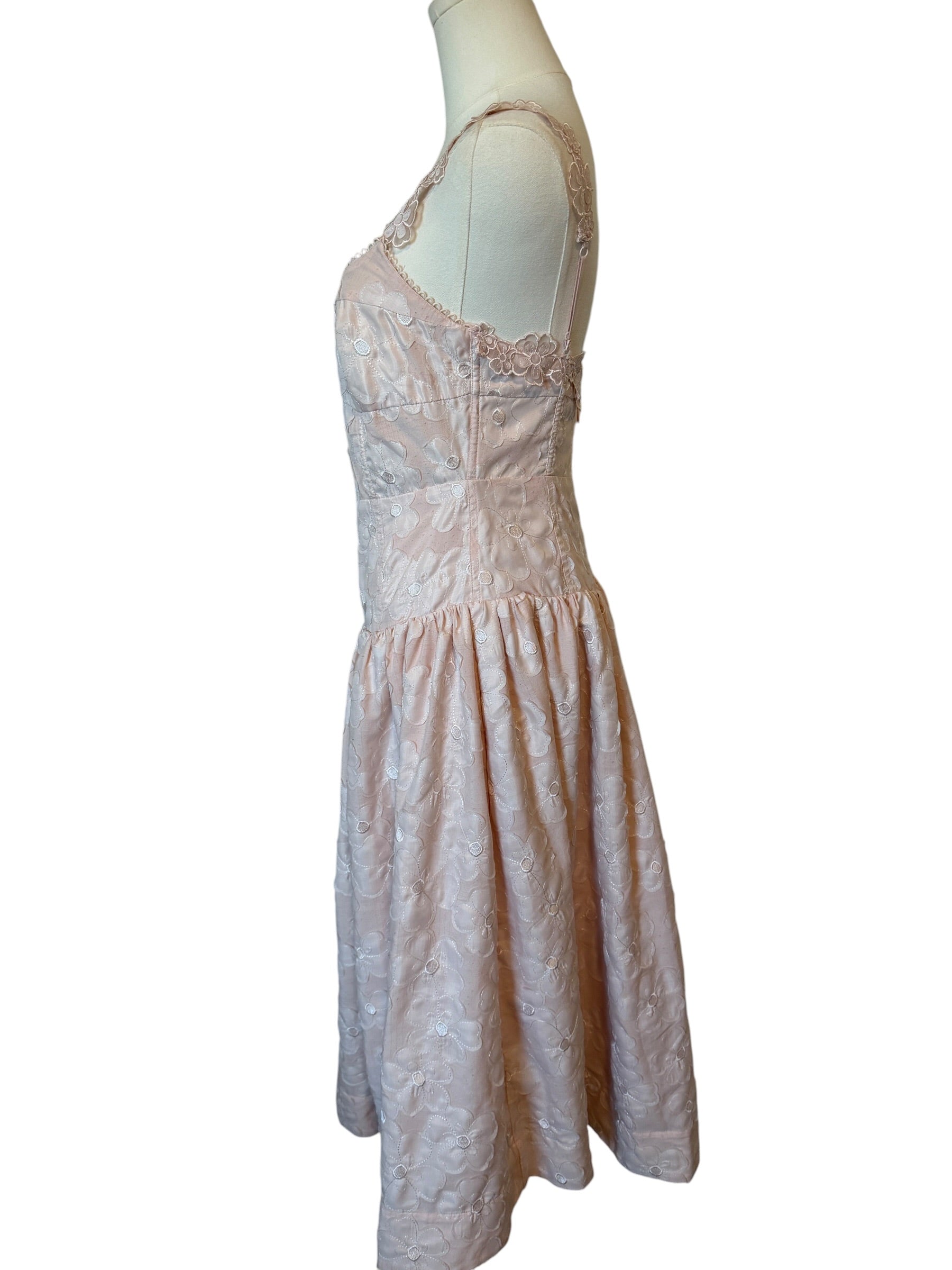 Light pink lace dress on a mannequin against a white background