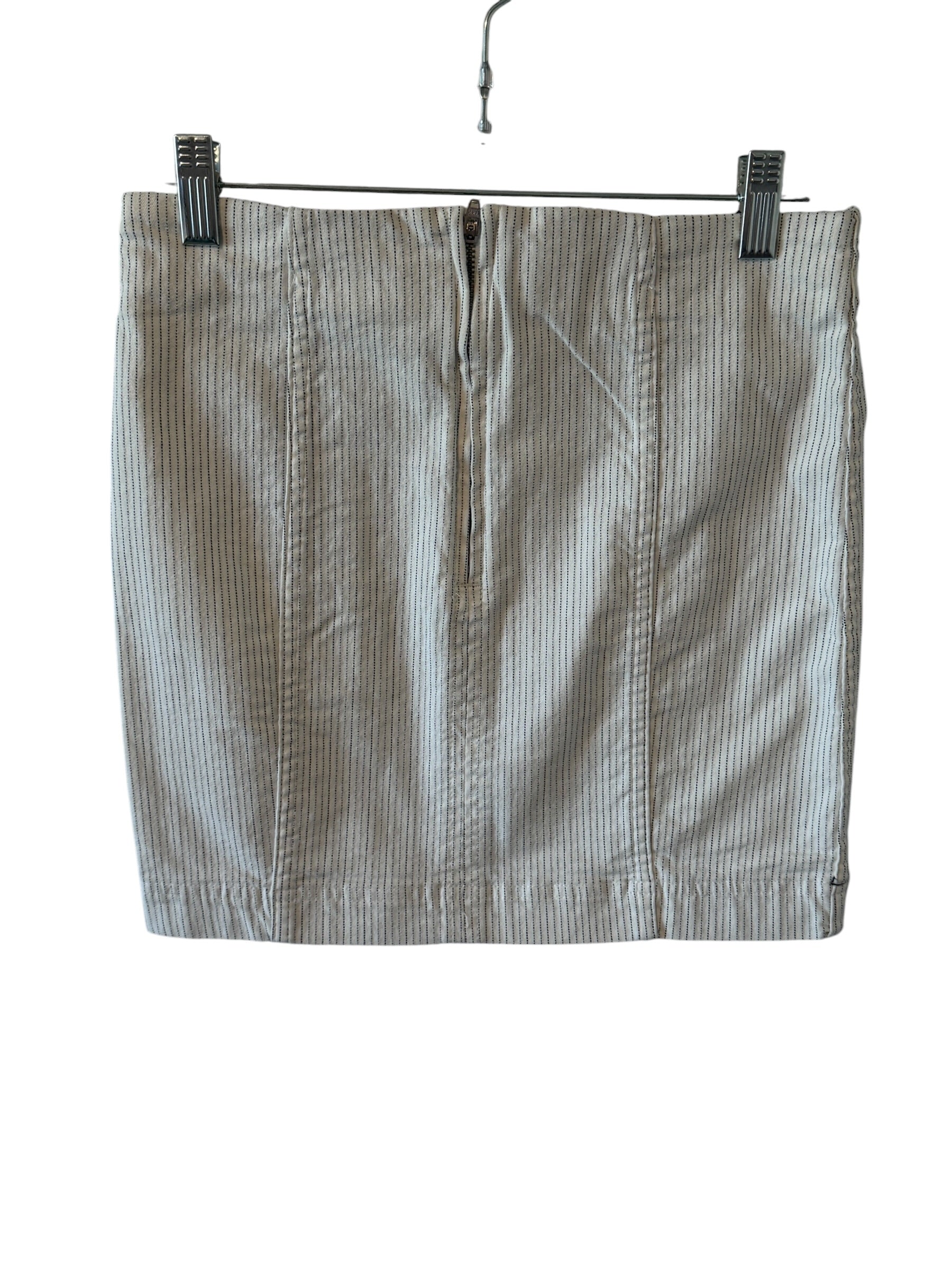 Striped skirt hanging on a rack with clips against a white background