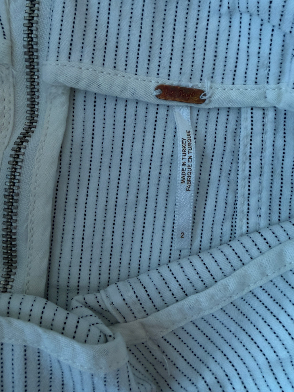 Close-up of a textured fabric with a zipper and label.