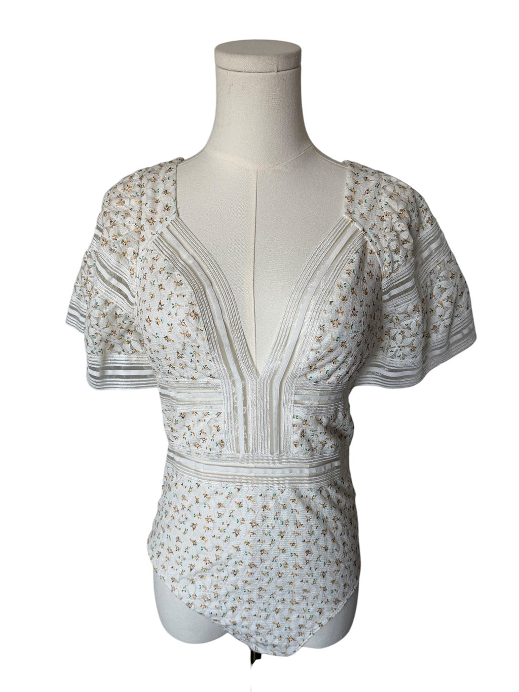 White floral dress on a mannequin against a white background