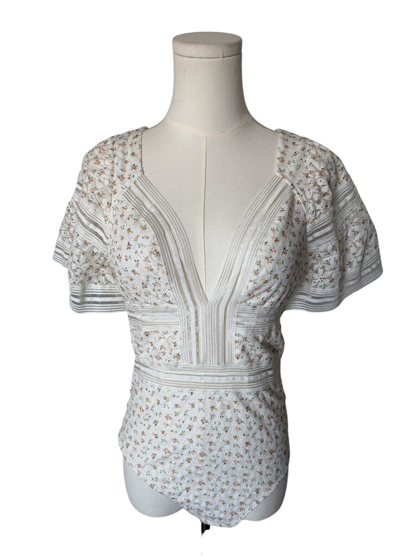 White floral dress on a mannequin against a white background