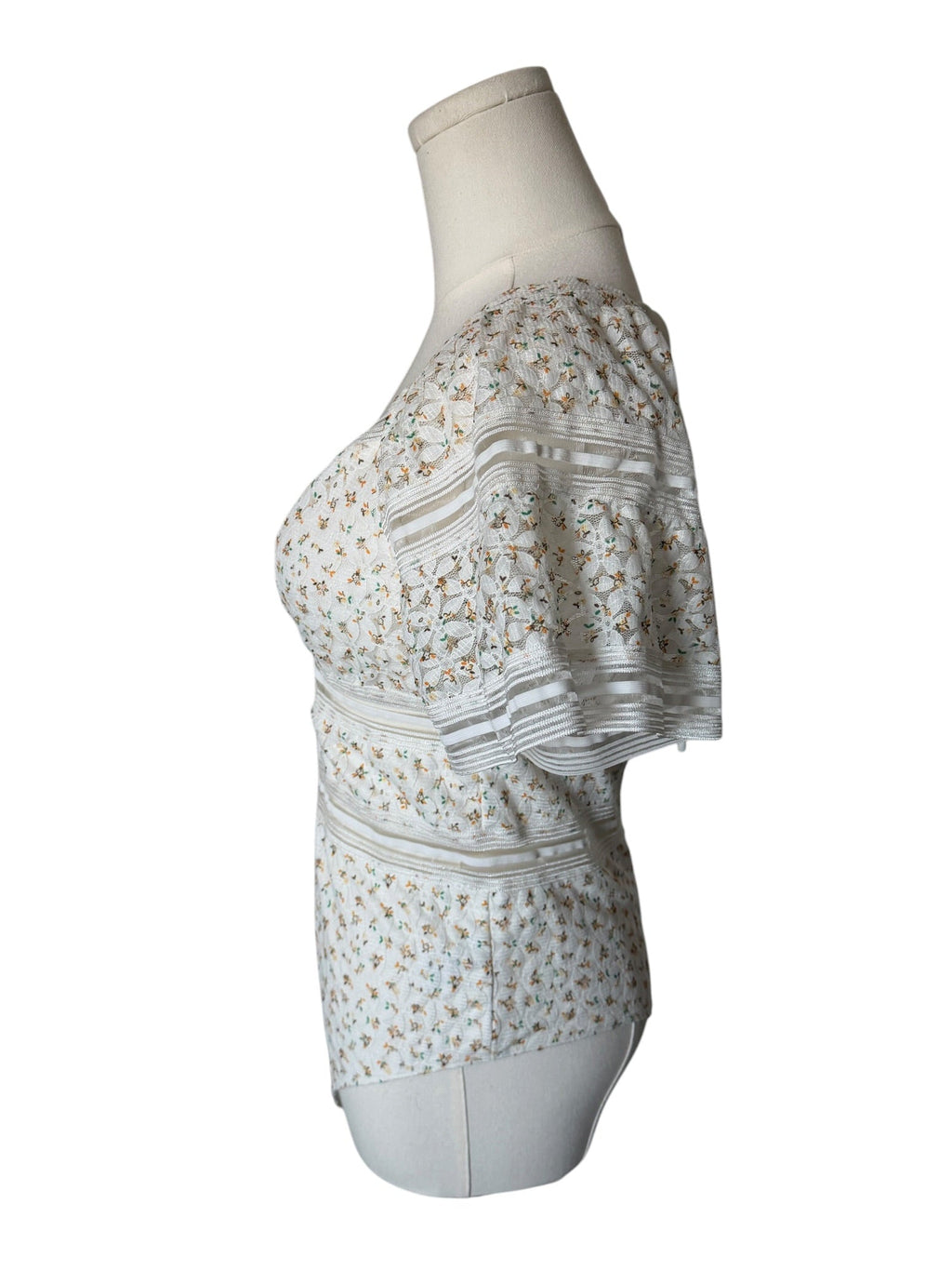 White dress with floral pattern on a mannequin against a white background