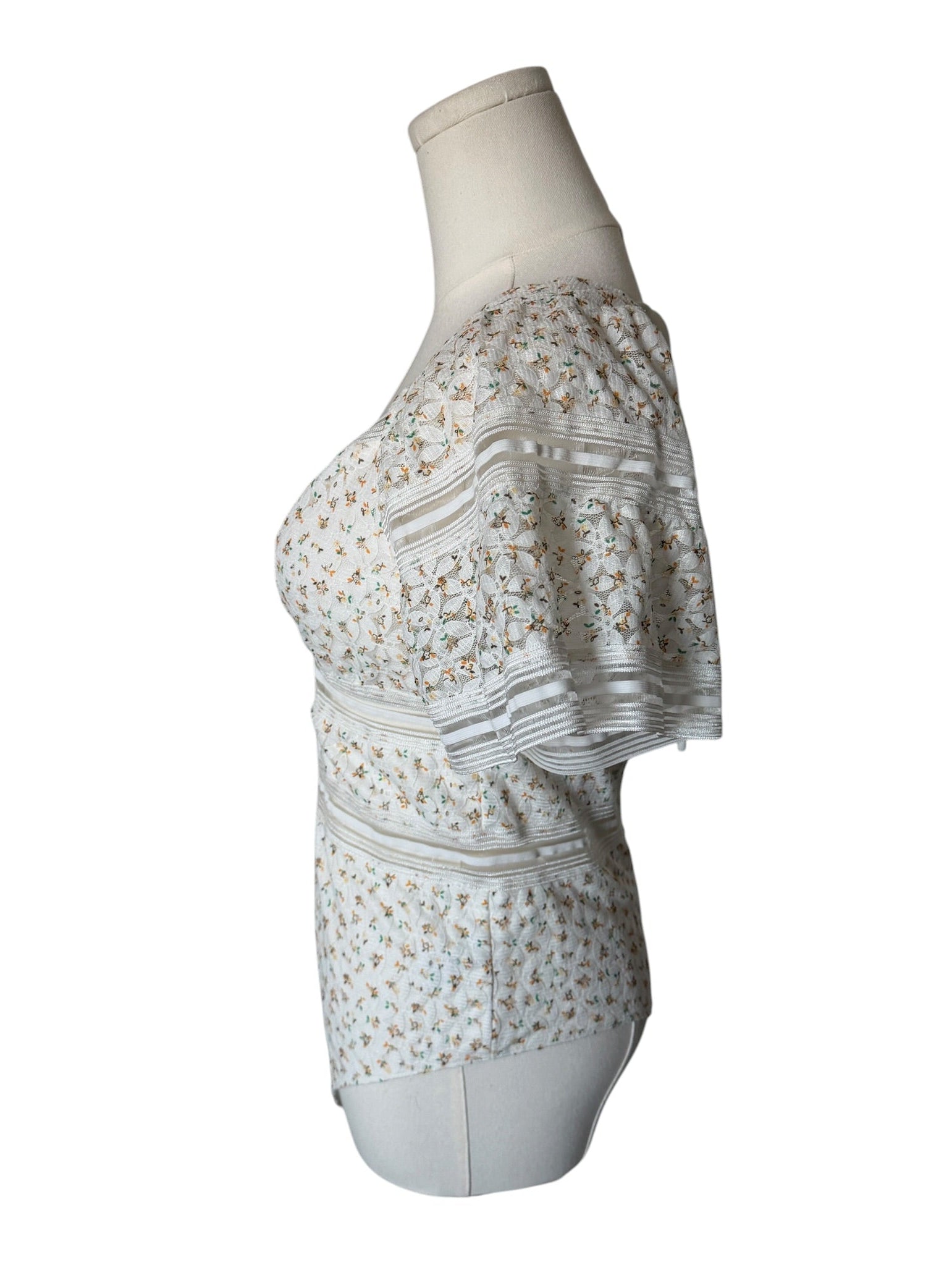 White dress with floral pattern on a mannequin against a white background