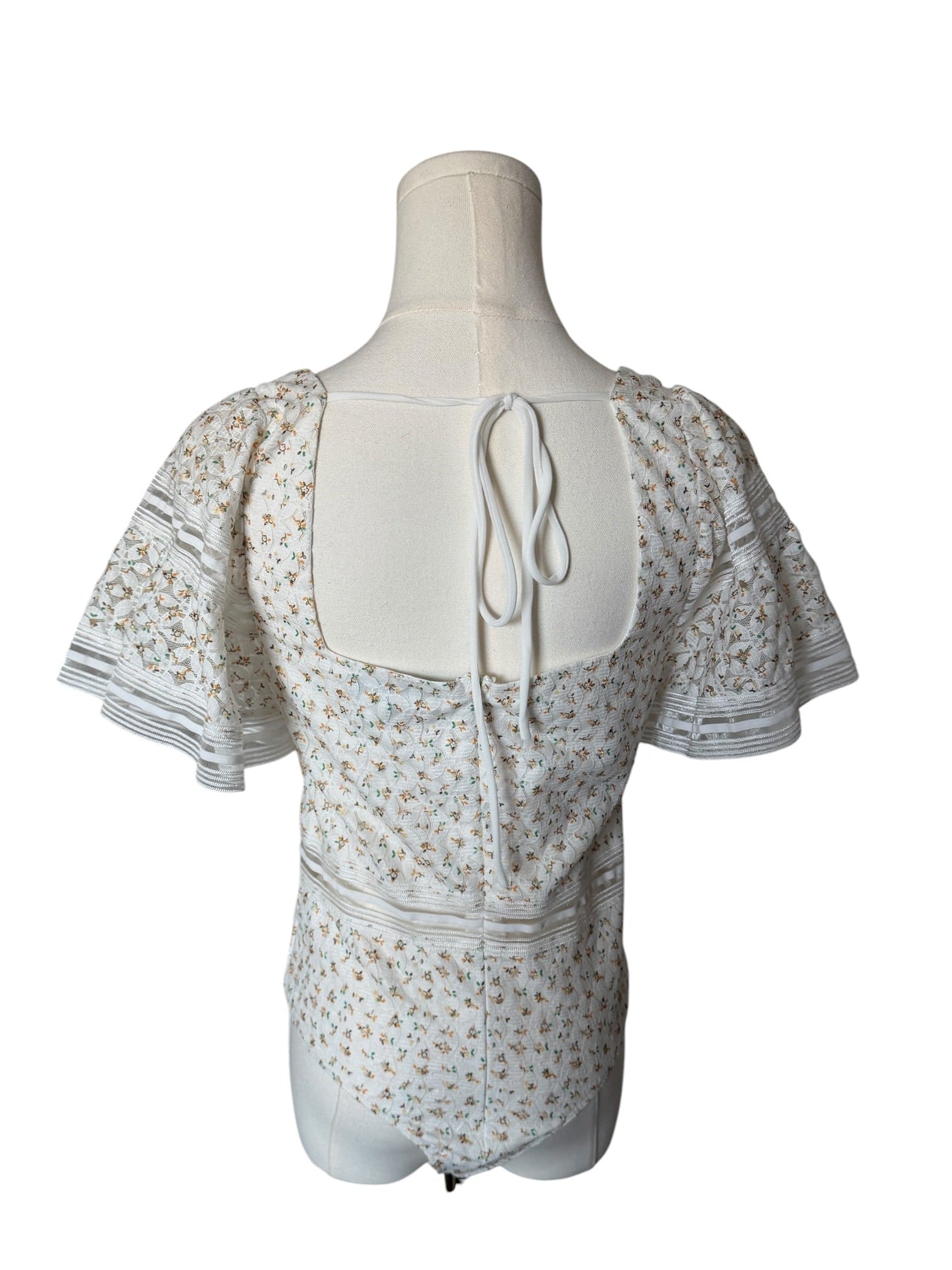 White floral dress on a mannequin against a white background