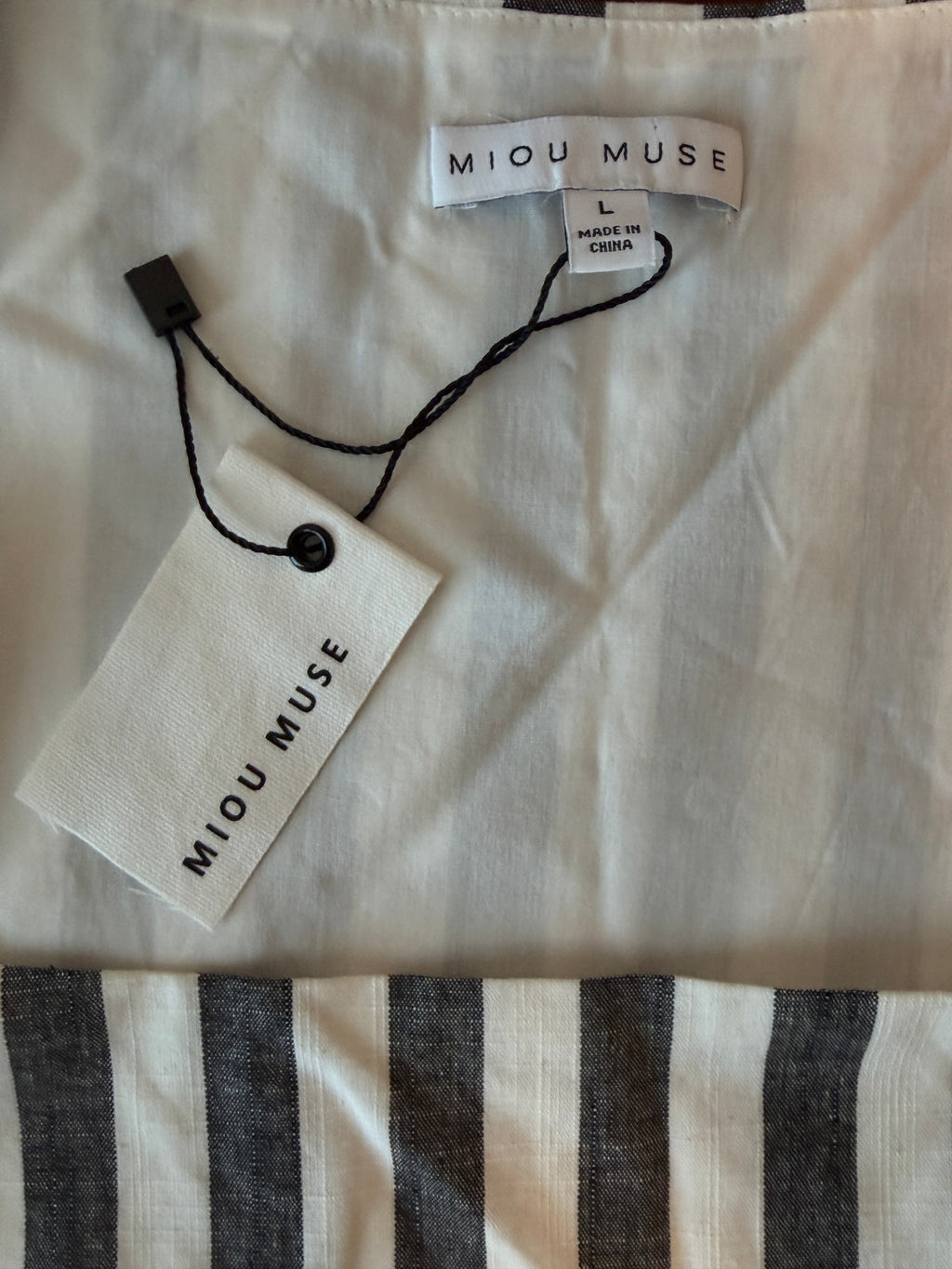 Miu Muse clothing tag on a fabric background