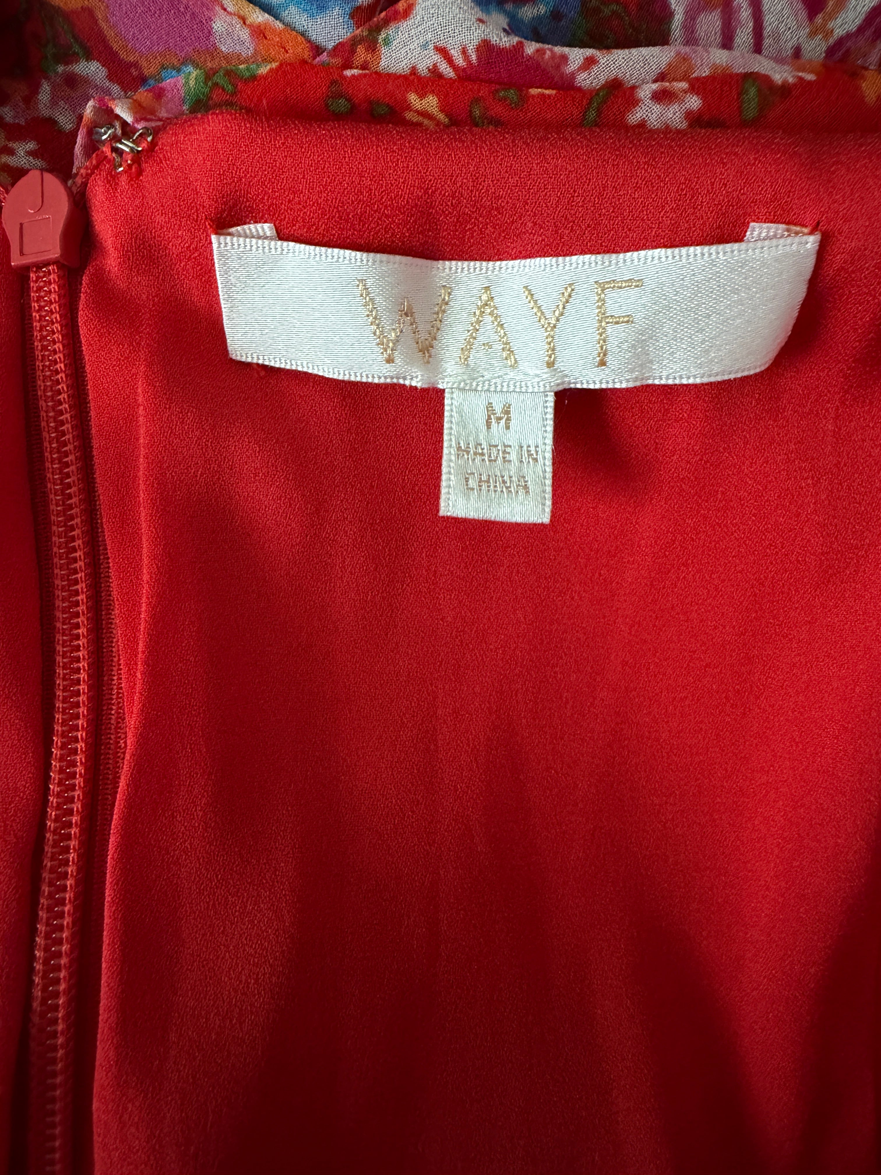 Red jacket with a visible 'WAYF' label on a colorful background
