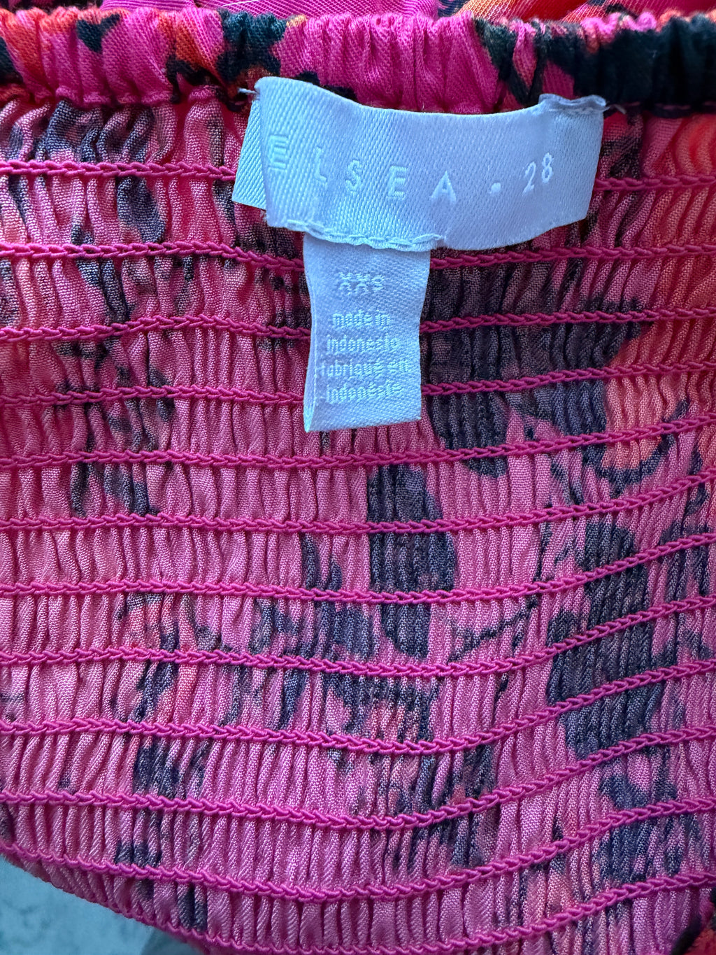 Close-up of a pink textured fabric with a label on it.