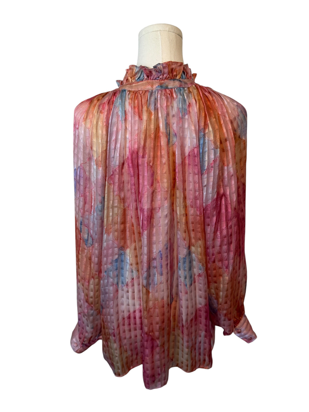 Multicolored sheer blouse on a mannequin against a white background
