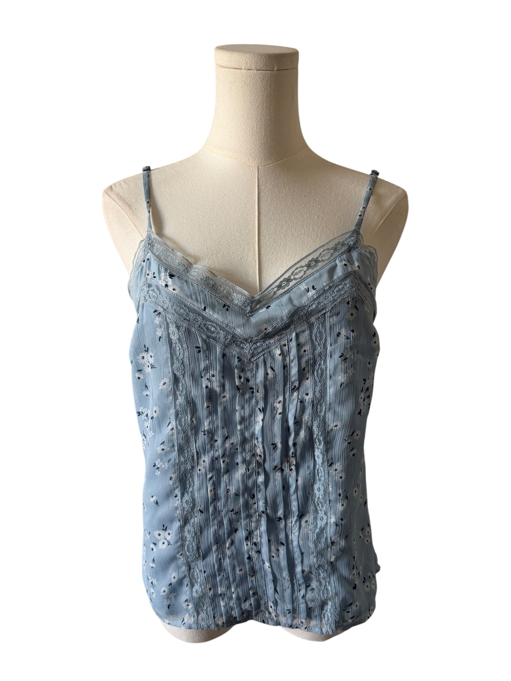Blue lace top on a mannequin against a white background